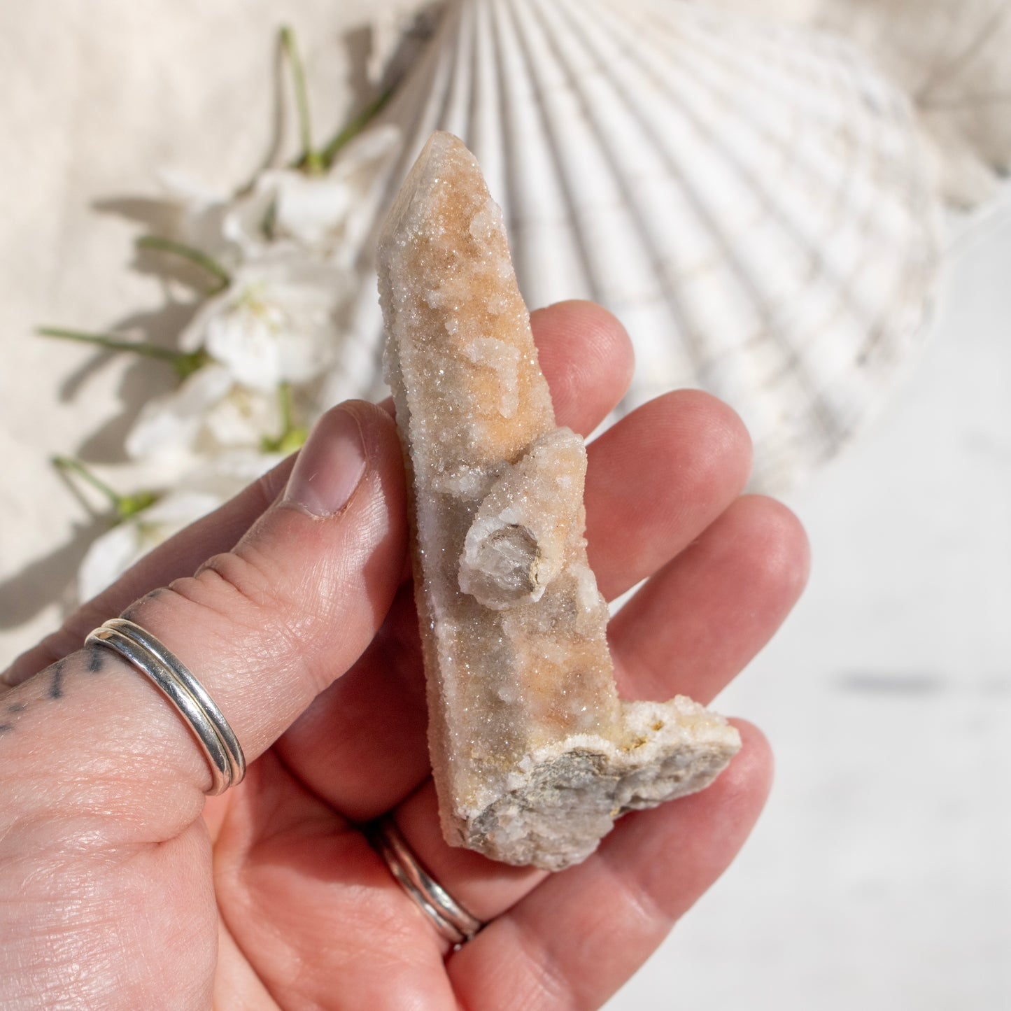 Hand holding a crystal with a blurred natural background
