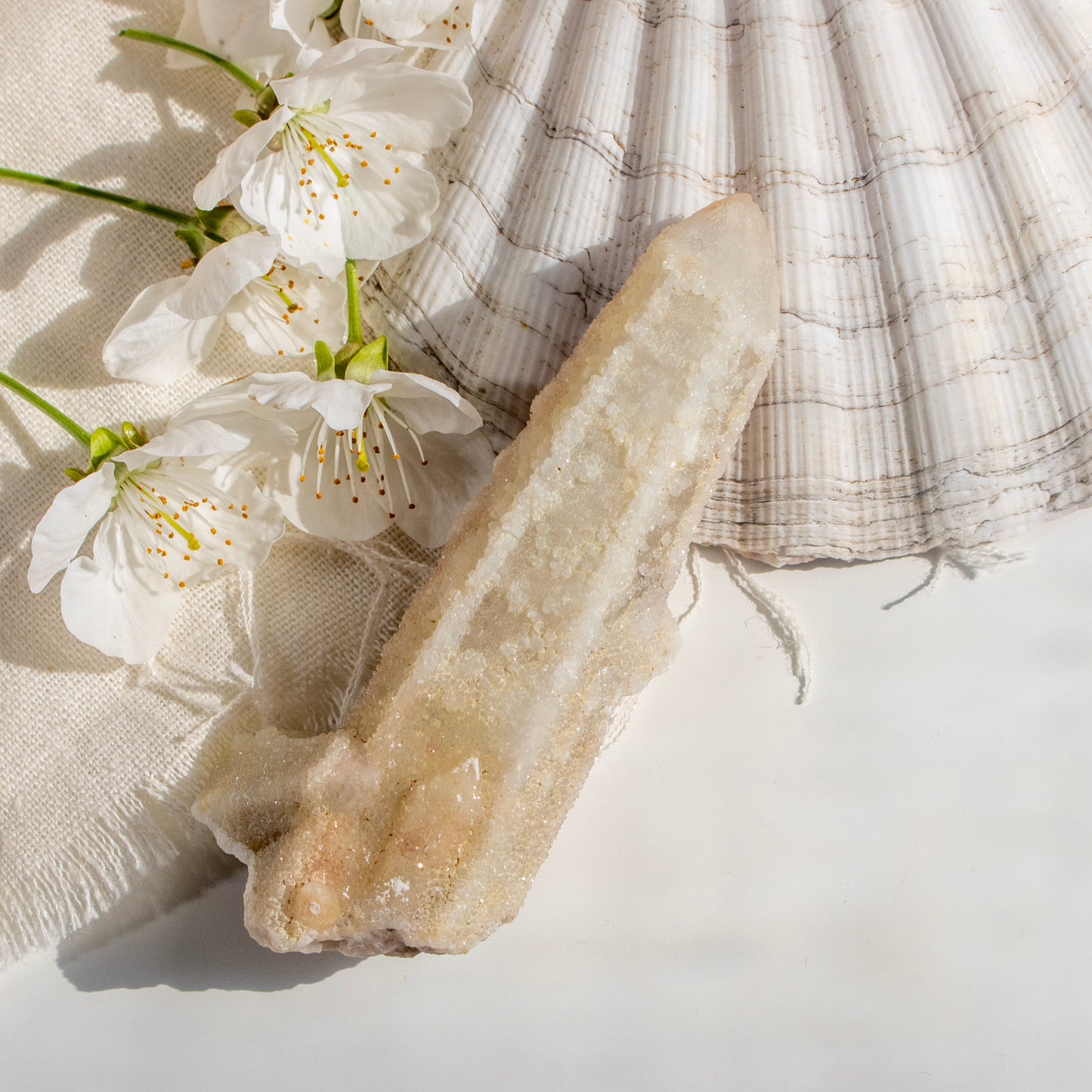 Geode crystal with white flowers on a textured fabric background