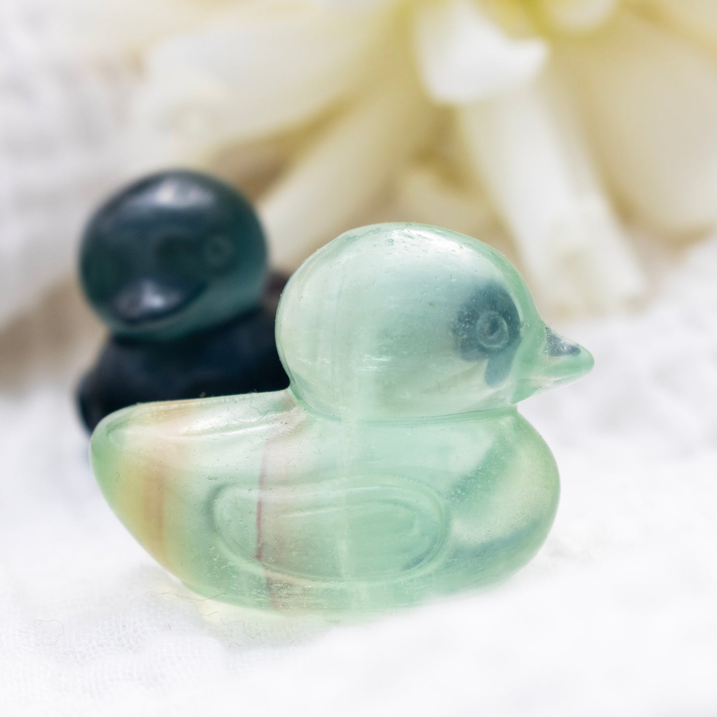 Two fluorite duck-shaped crystals on a white background