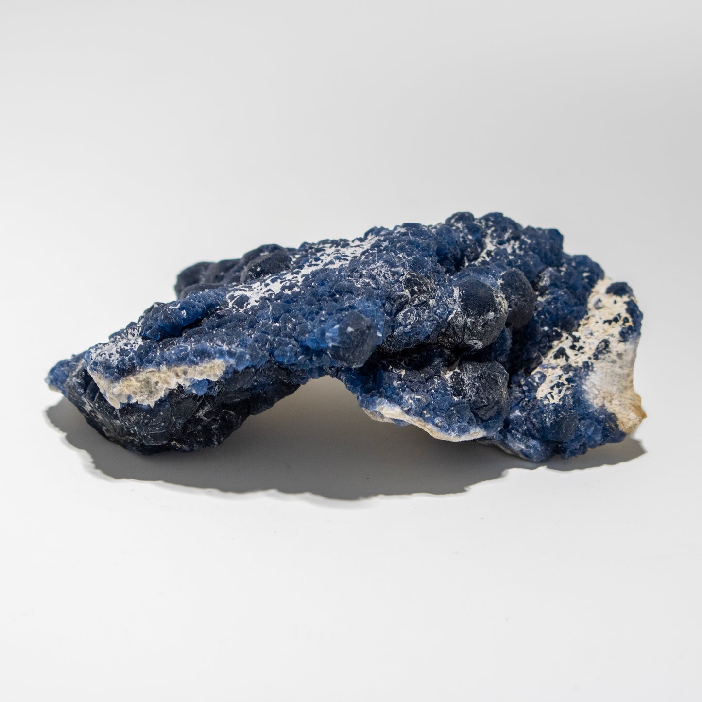 Blue and white mineral rock on a light gray background