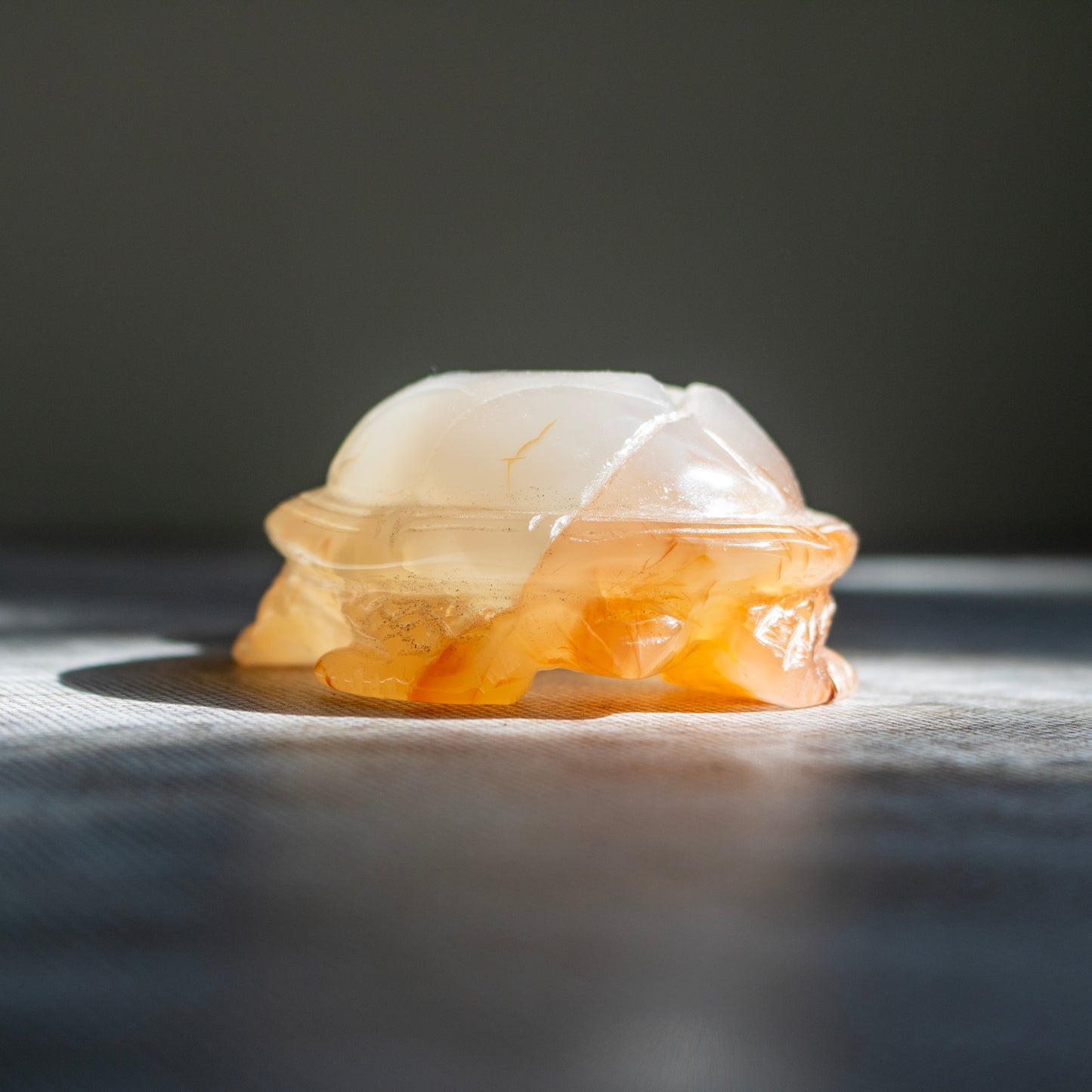 Translucent orange stone carving on a dark background