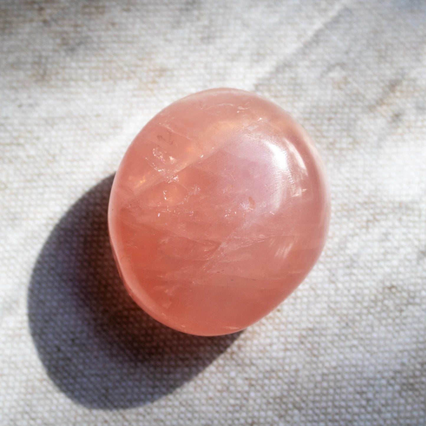 Pink crystal ball on a textured fabric background