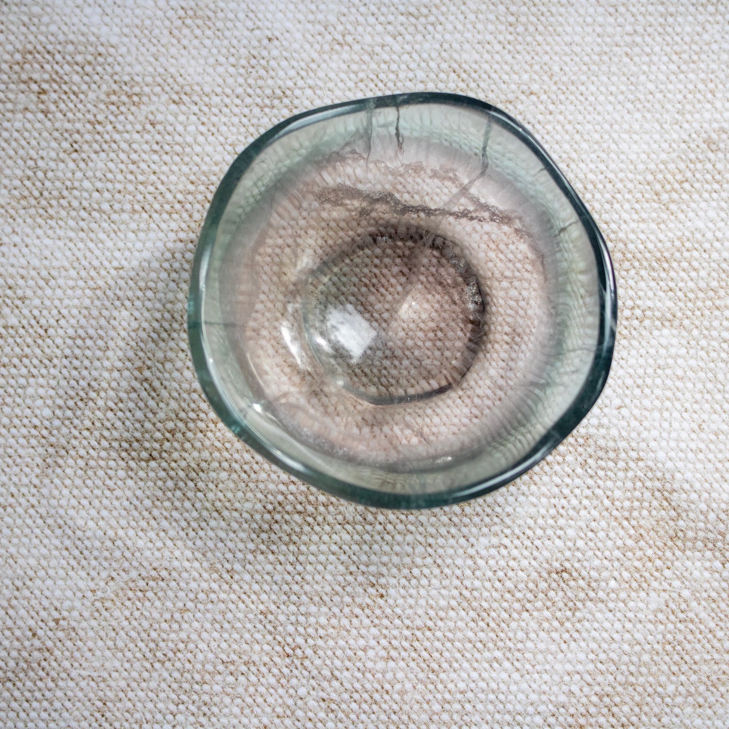 Clear crystal bowl on a textured beige surface