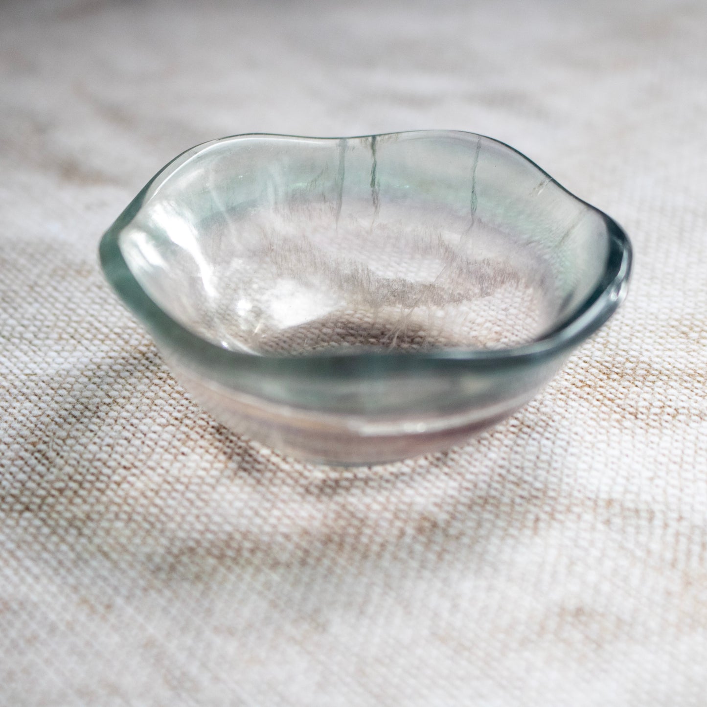 Clear crystal bowl on a textured fabric surface