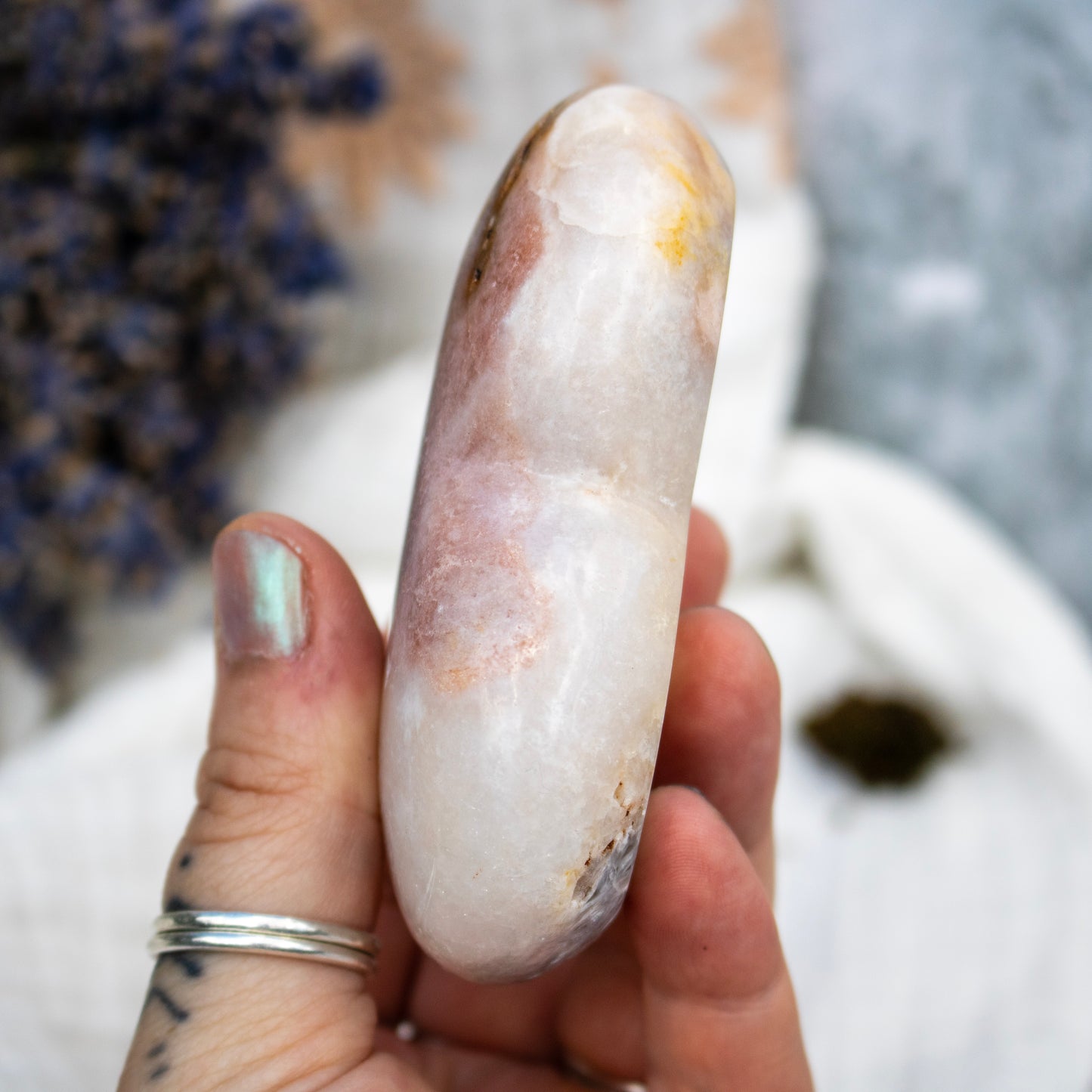Hand holding a large crystal with a blurred natural background