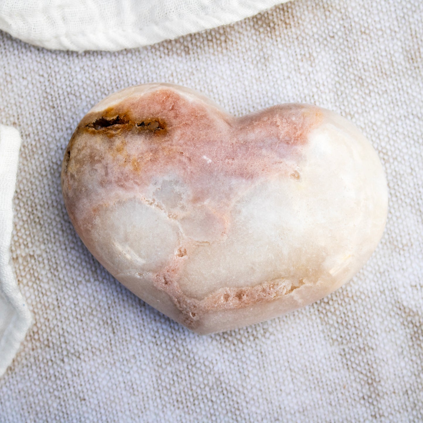 Heart-shaped stone on a textured fabric background
