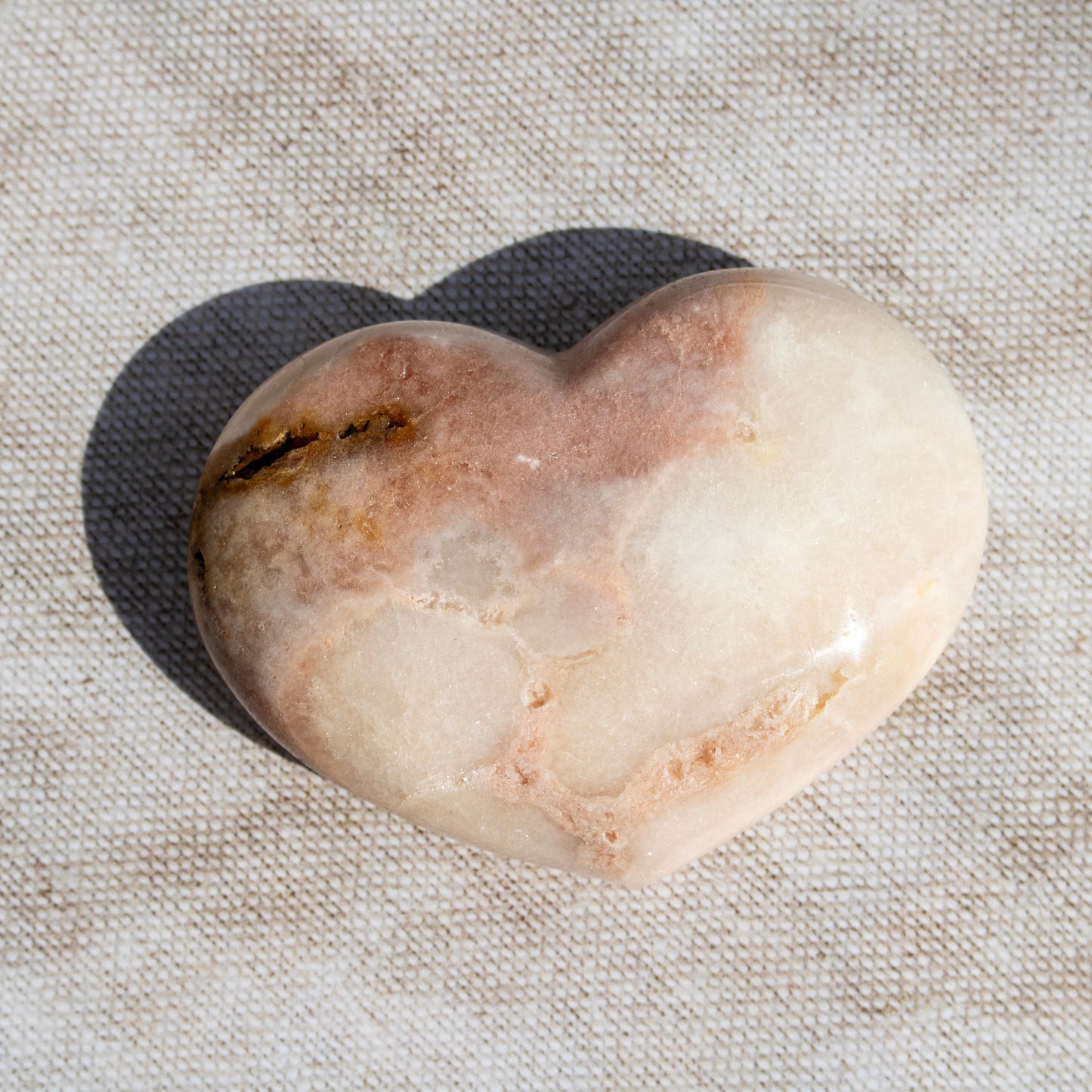 Heart-shaped stone on a textured fabric background