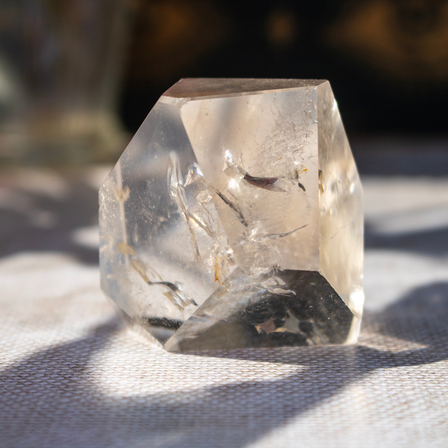 Clear crystal prism on a textured surface with a blurred background