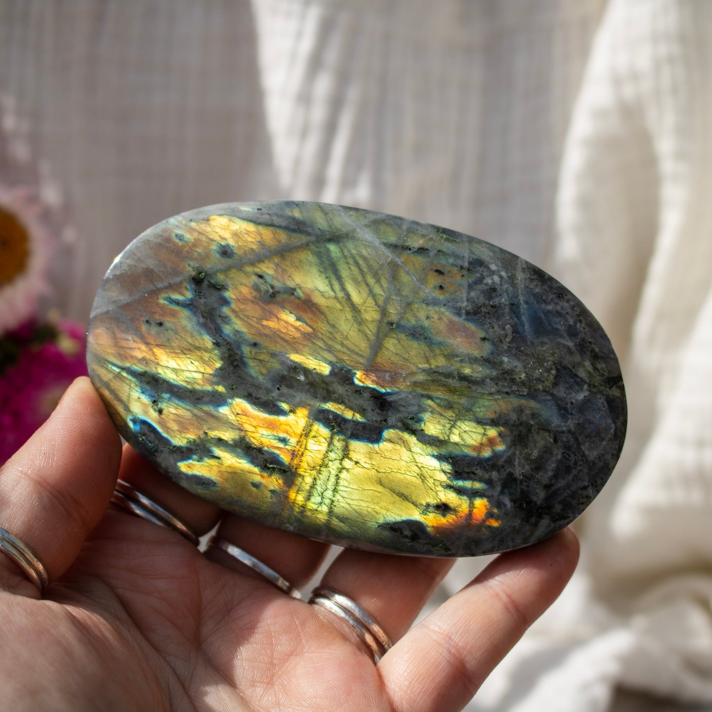 Hand holding a crystal against a neutral background