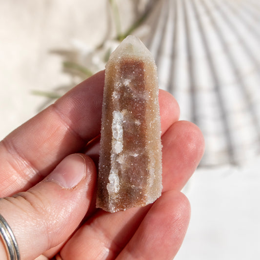 Hand holding a crystal with a natural background