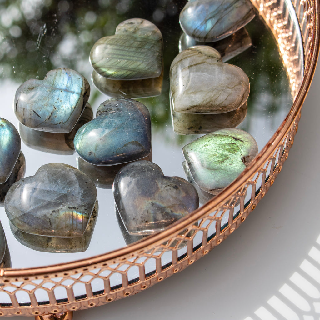 Heart-shaped stones on a decorative mirror with a rose gold frame.