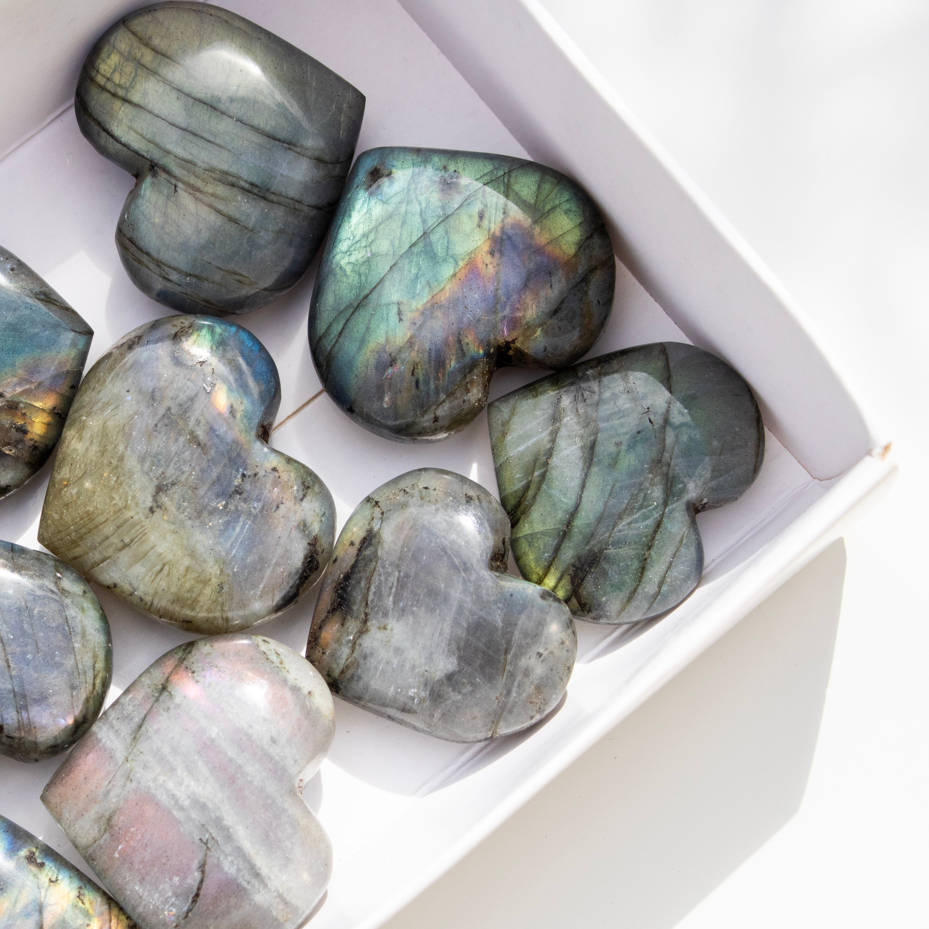 Heart-shaped labradorite stones in a white box