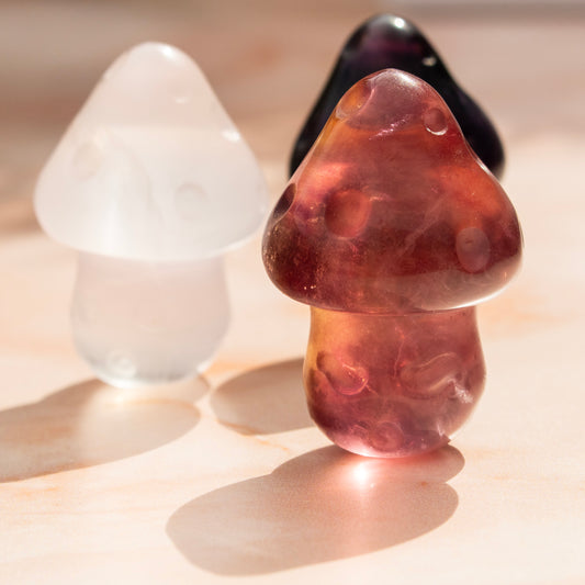 Three mushroom-shaped objects in different colors on a light background