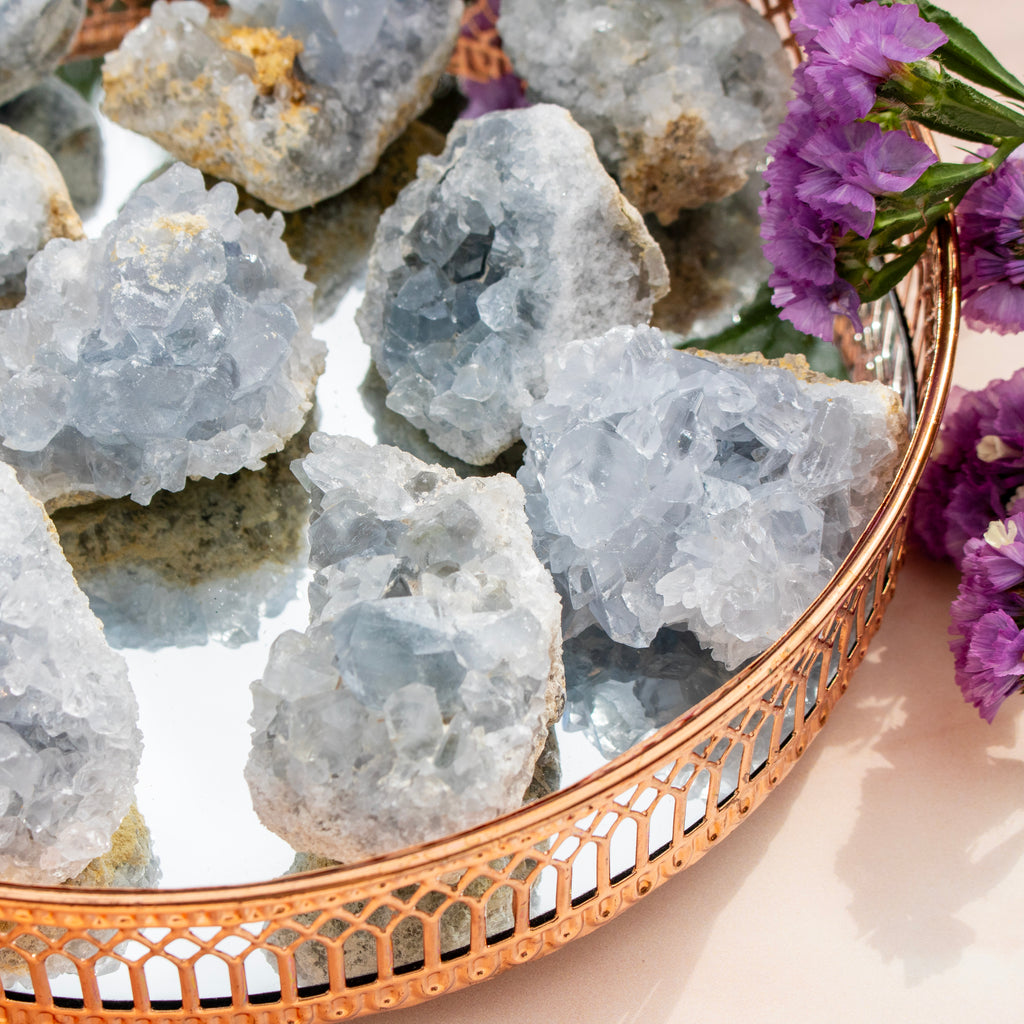 Geode crystals on a decorative tray with purple flowers