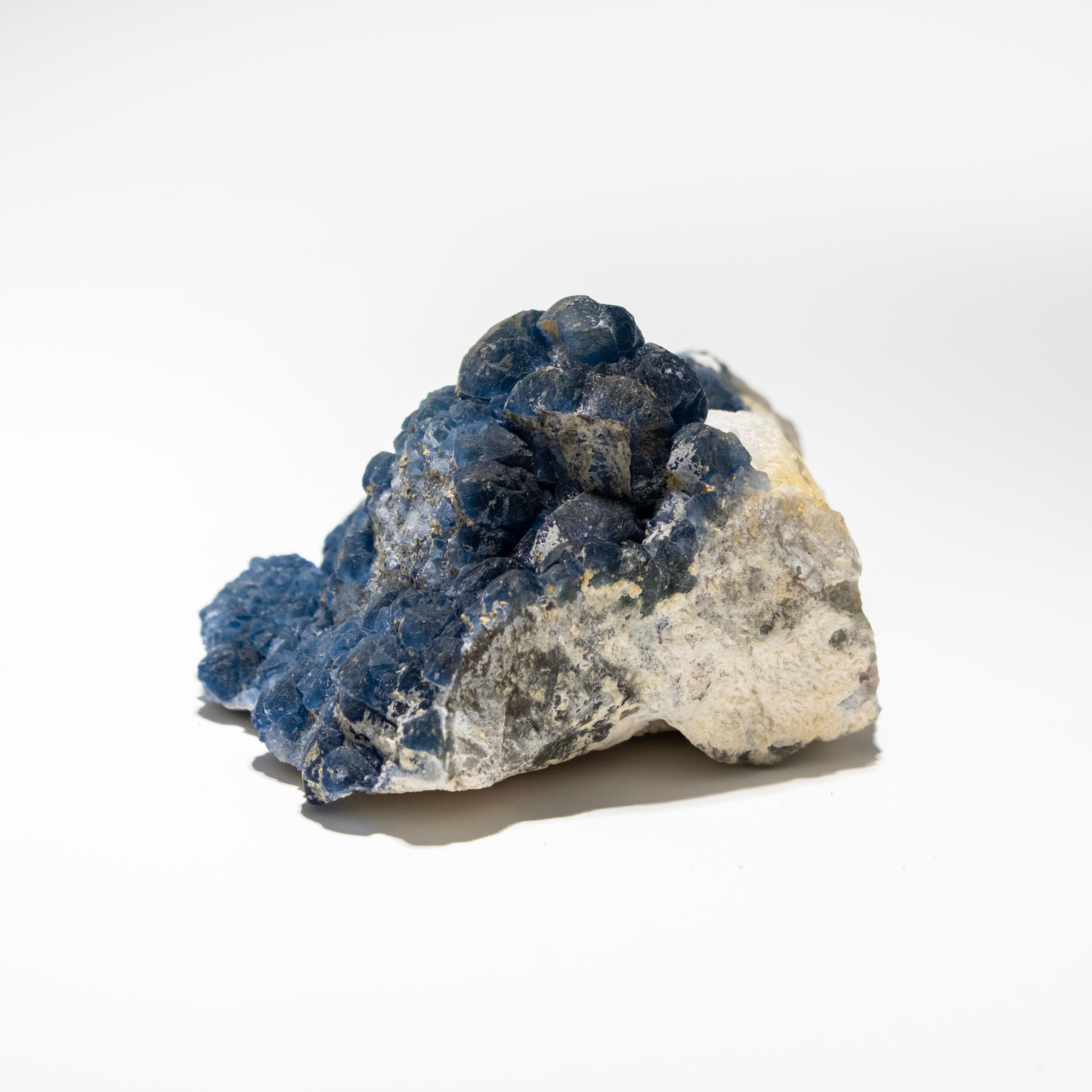 Mineral sample with blue and gray crystals on a white background