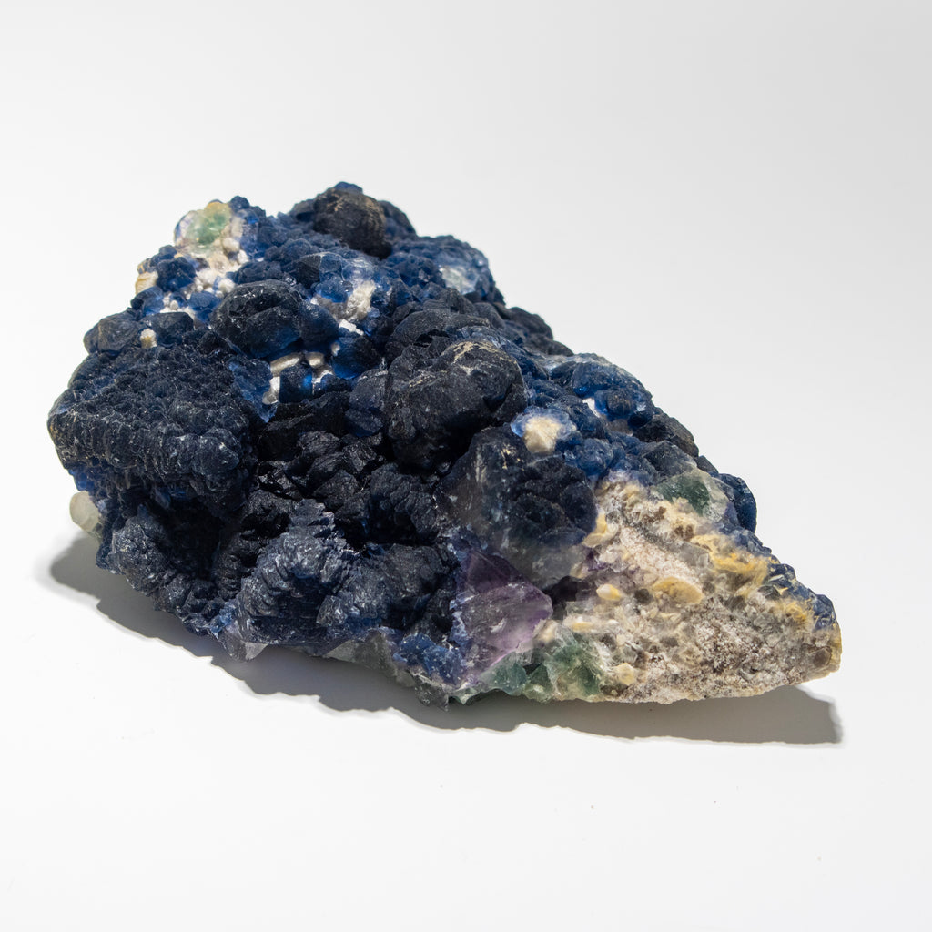 Mineral sample with blue and purple crystals on a white background
