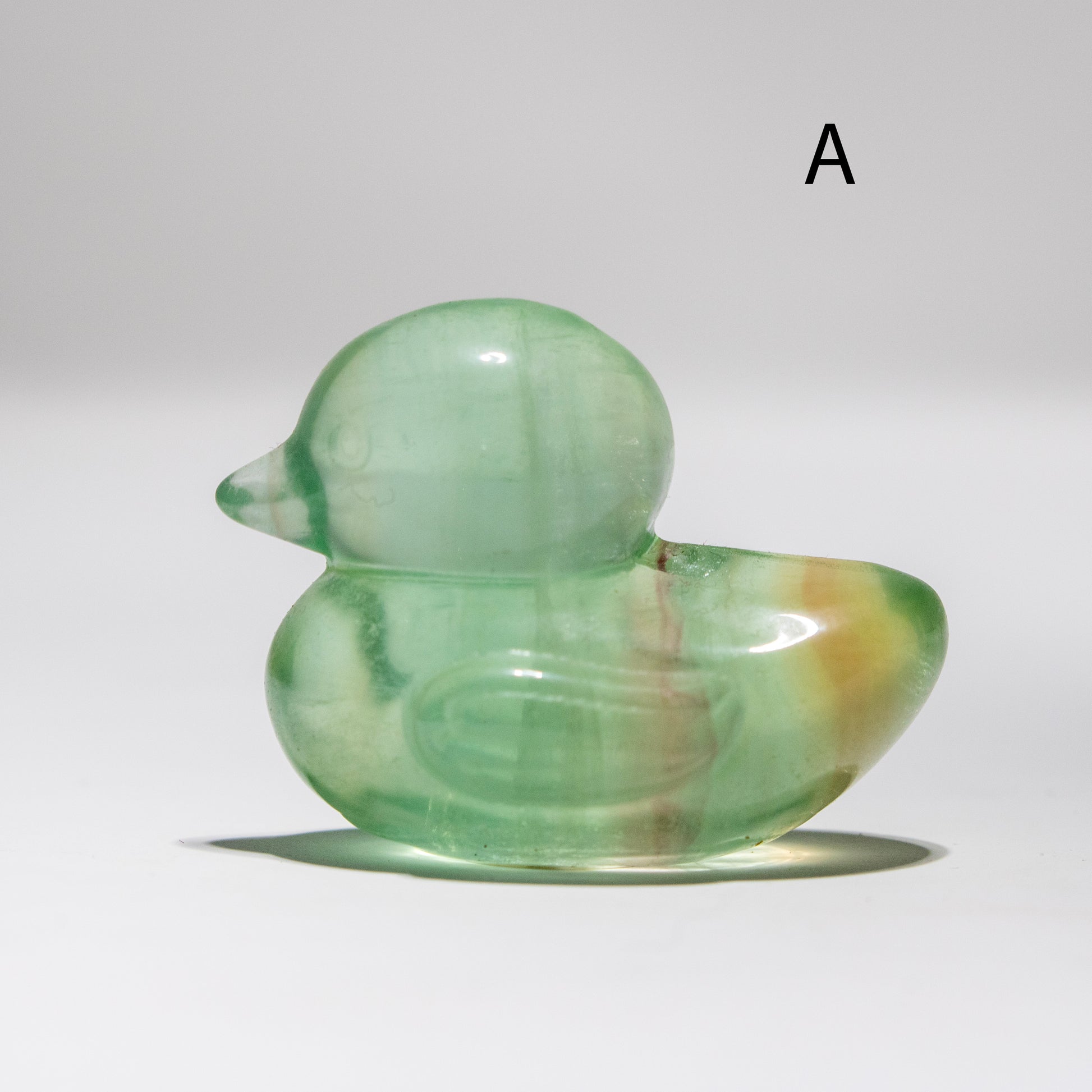 Green fluorite duck-shaped crystal on a white background