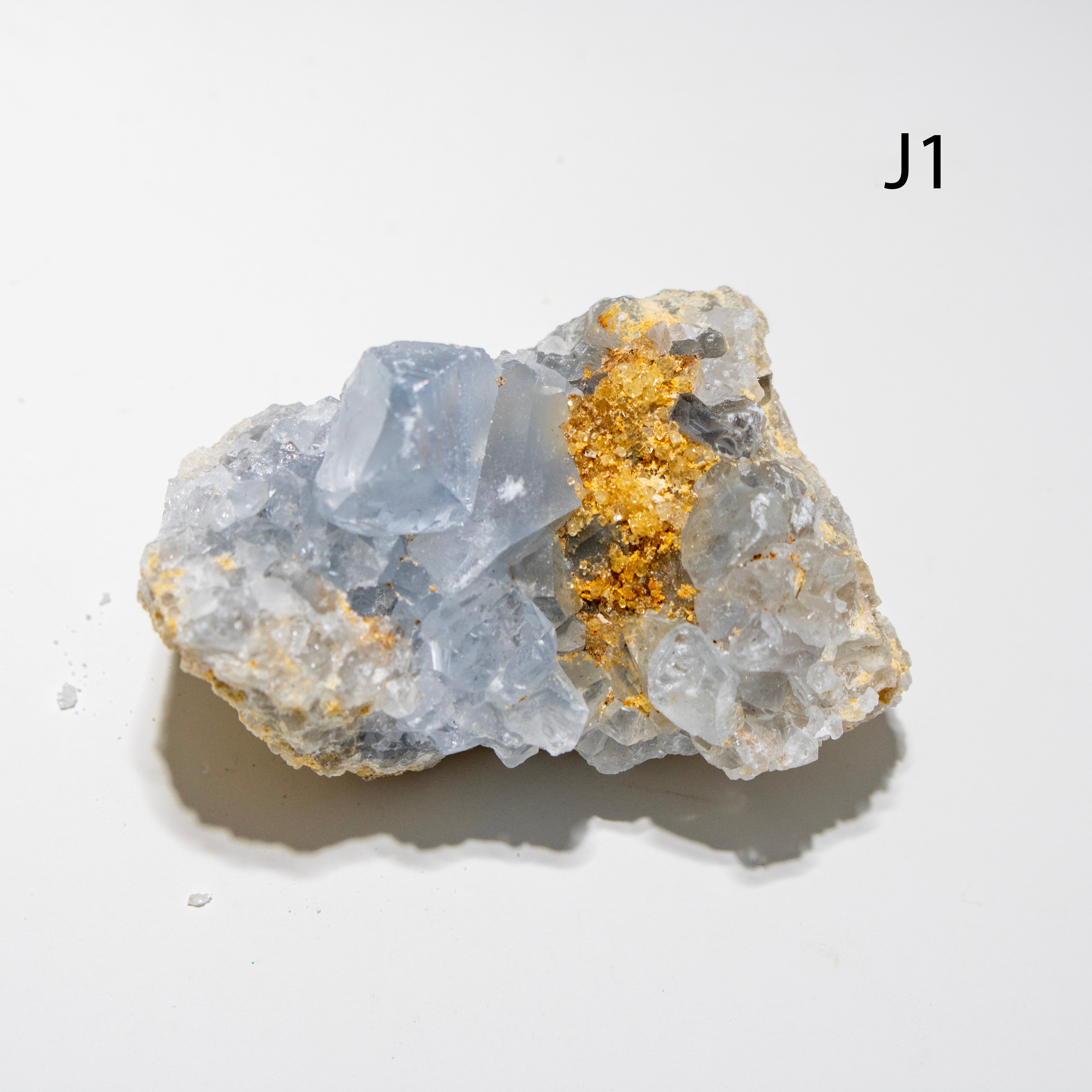 Mineral sample with crystals on a light gray background