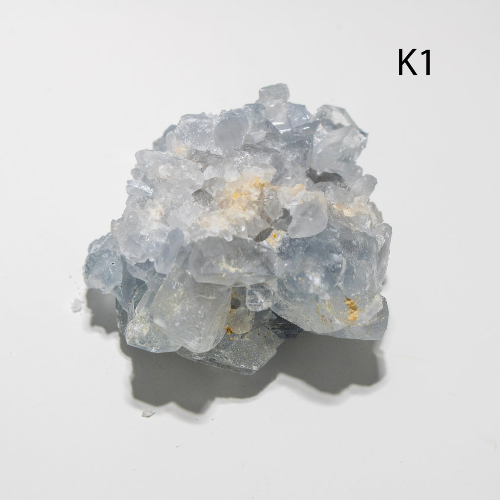 Cluster of clear crystal-like rocks on a light gray background with 'K1' label.