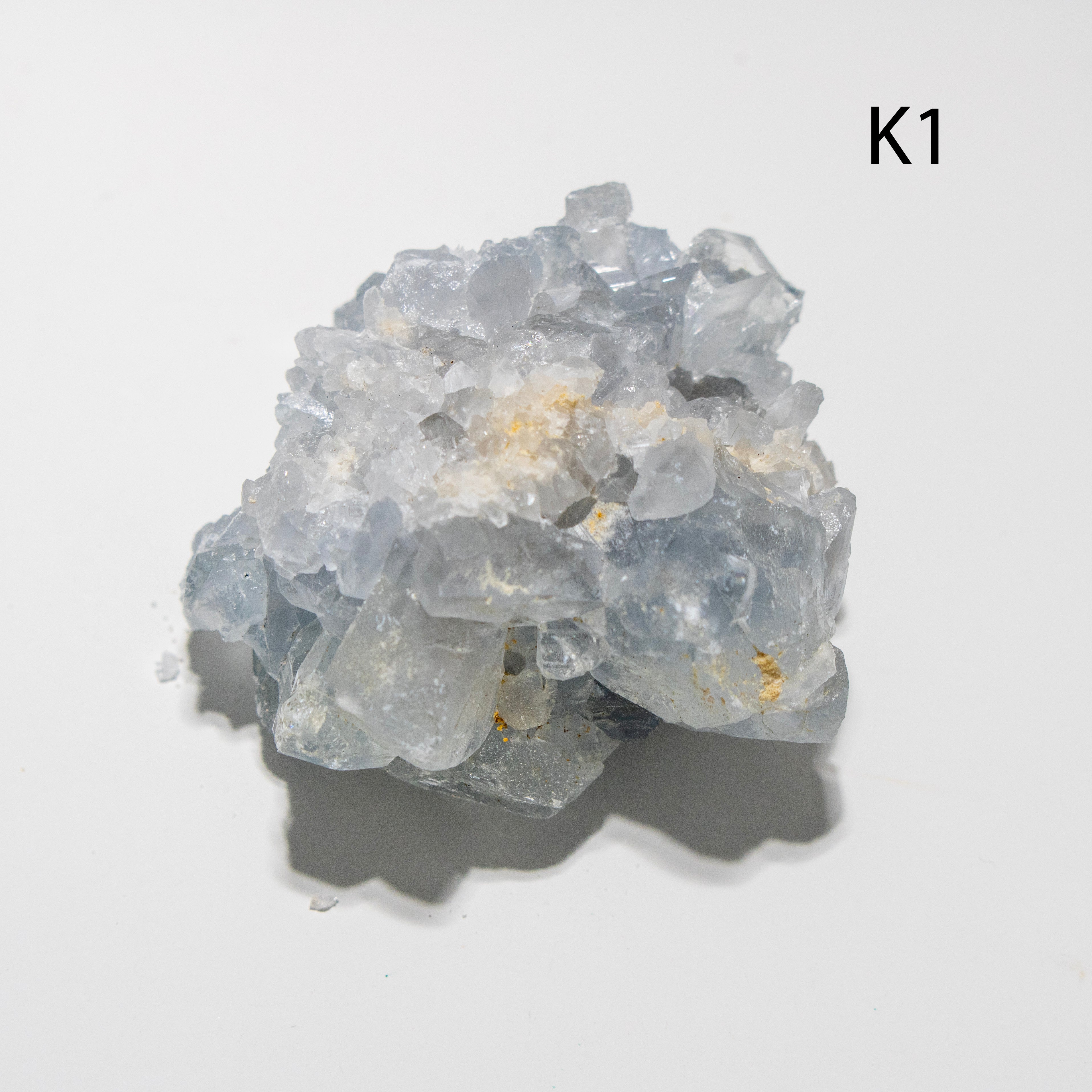 Cluster of clear crystal-like rocks on a light gray background with 'K1' label.