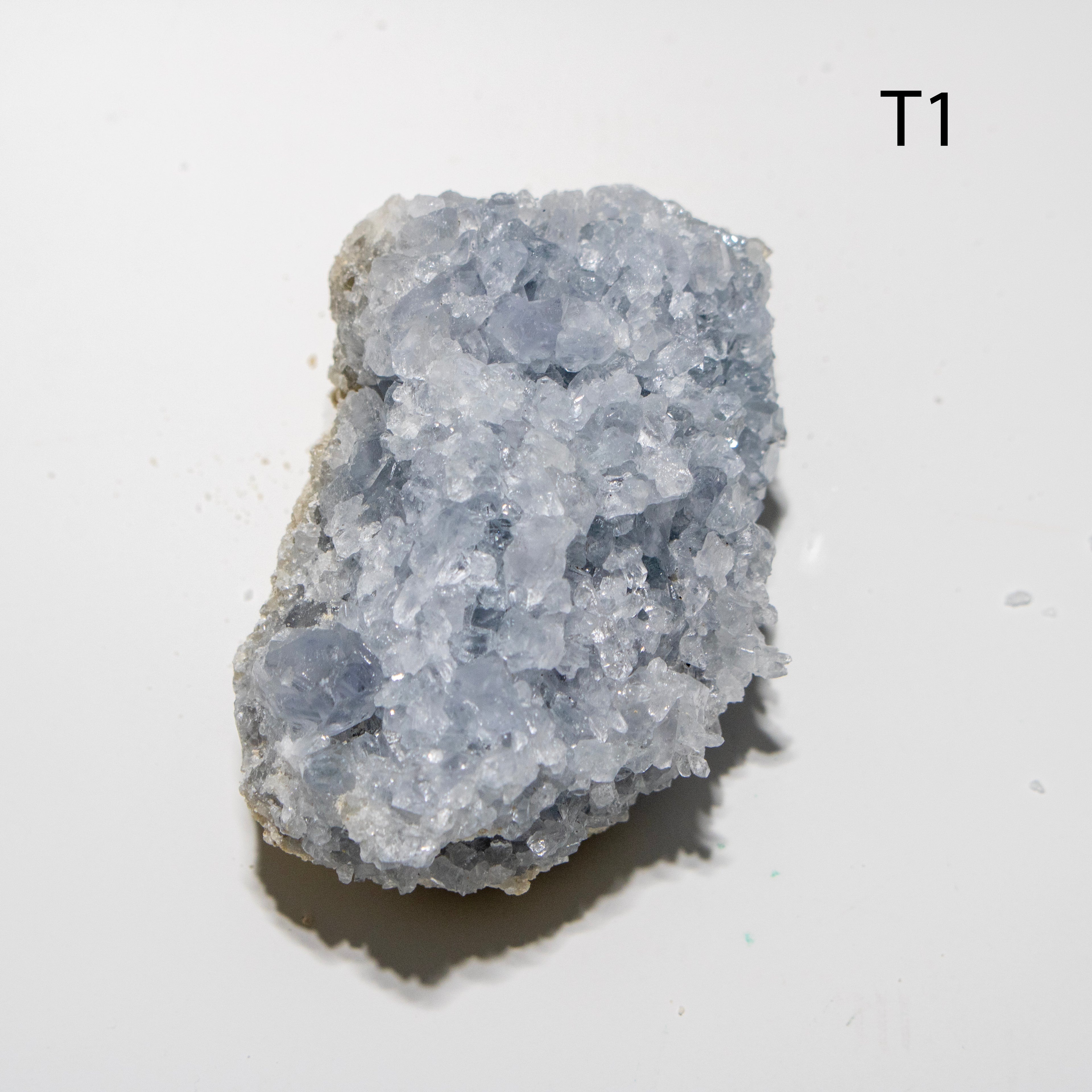 Blue celestite crystal on a white background.