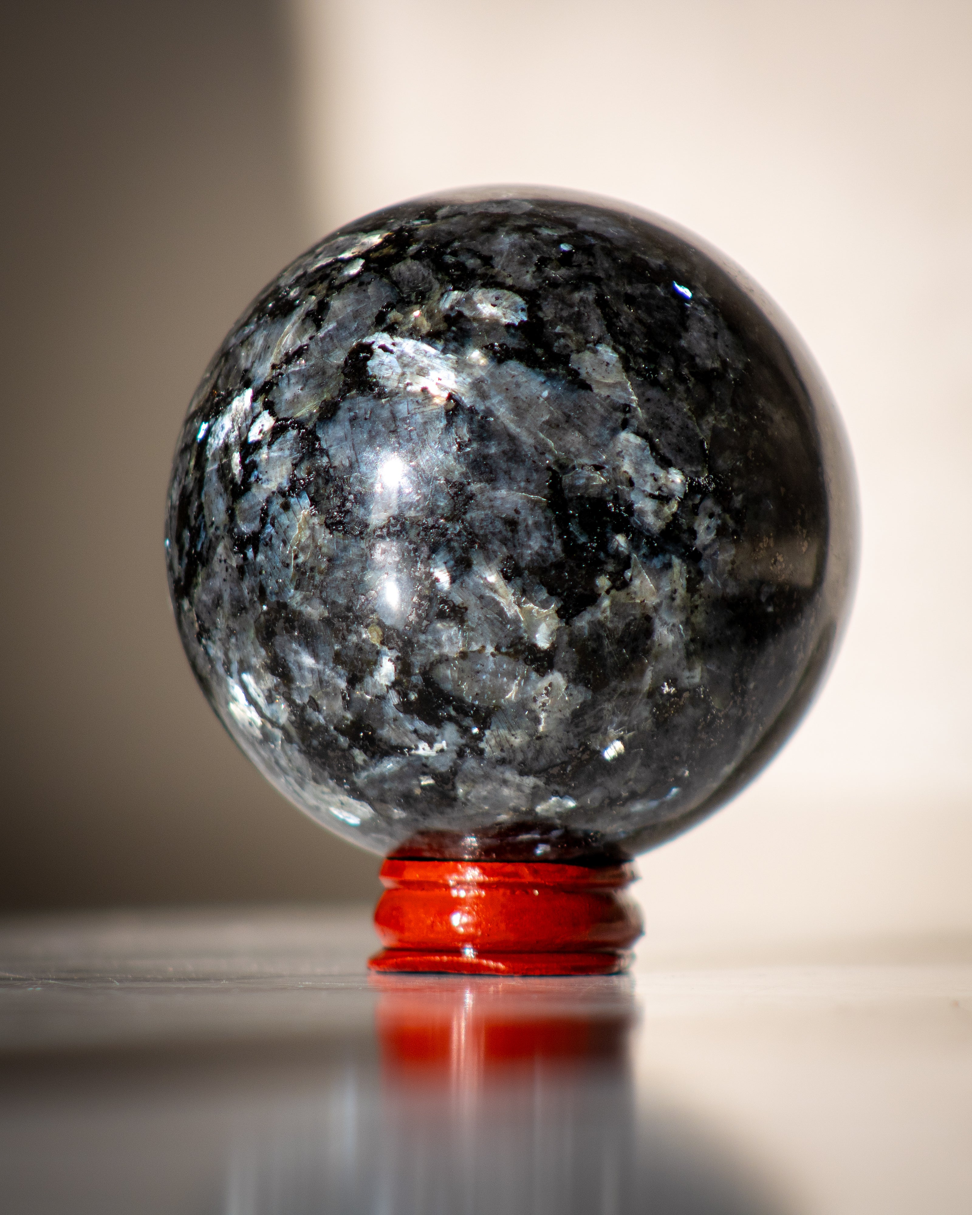 Crystal ball with a red base on a reflective surface