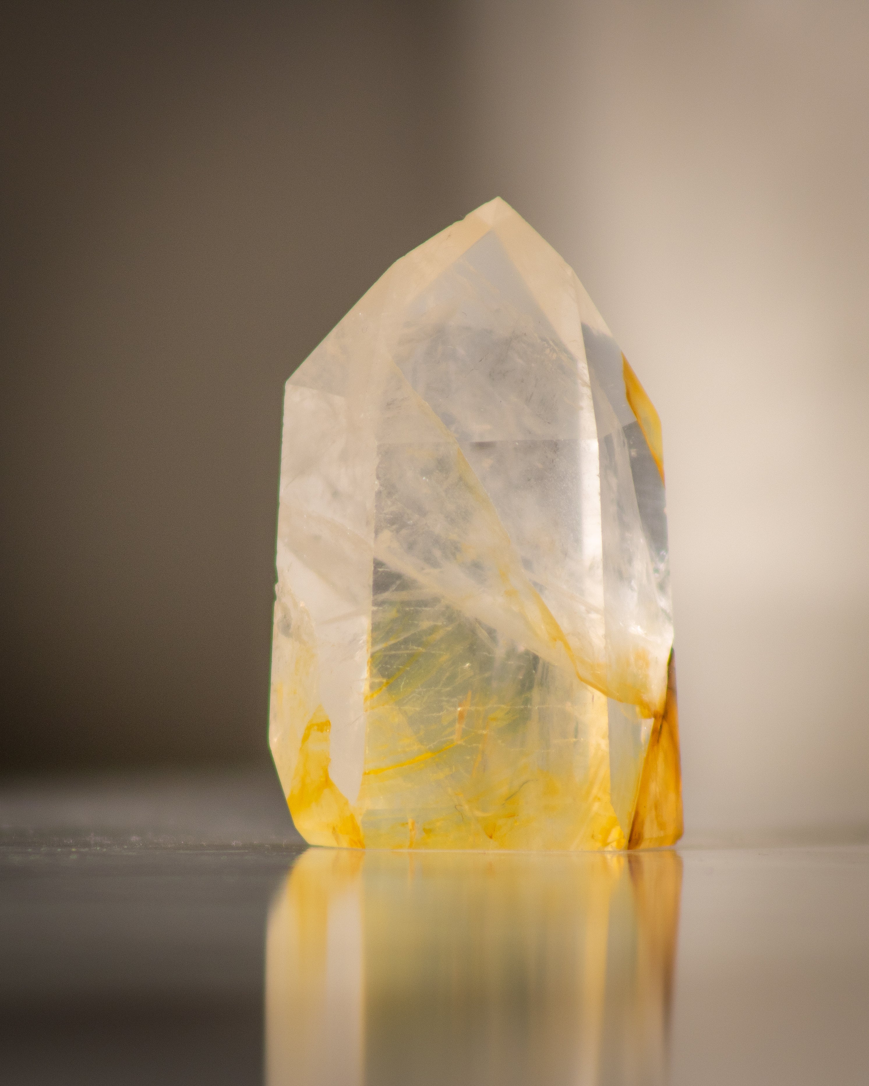 a clear quartz tower with veins of yellow hematite running through it 