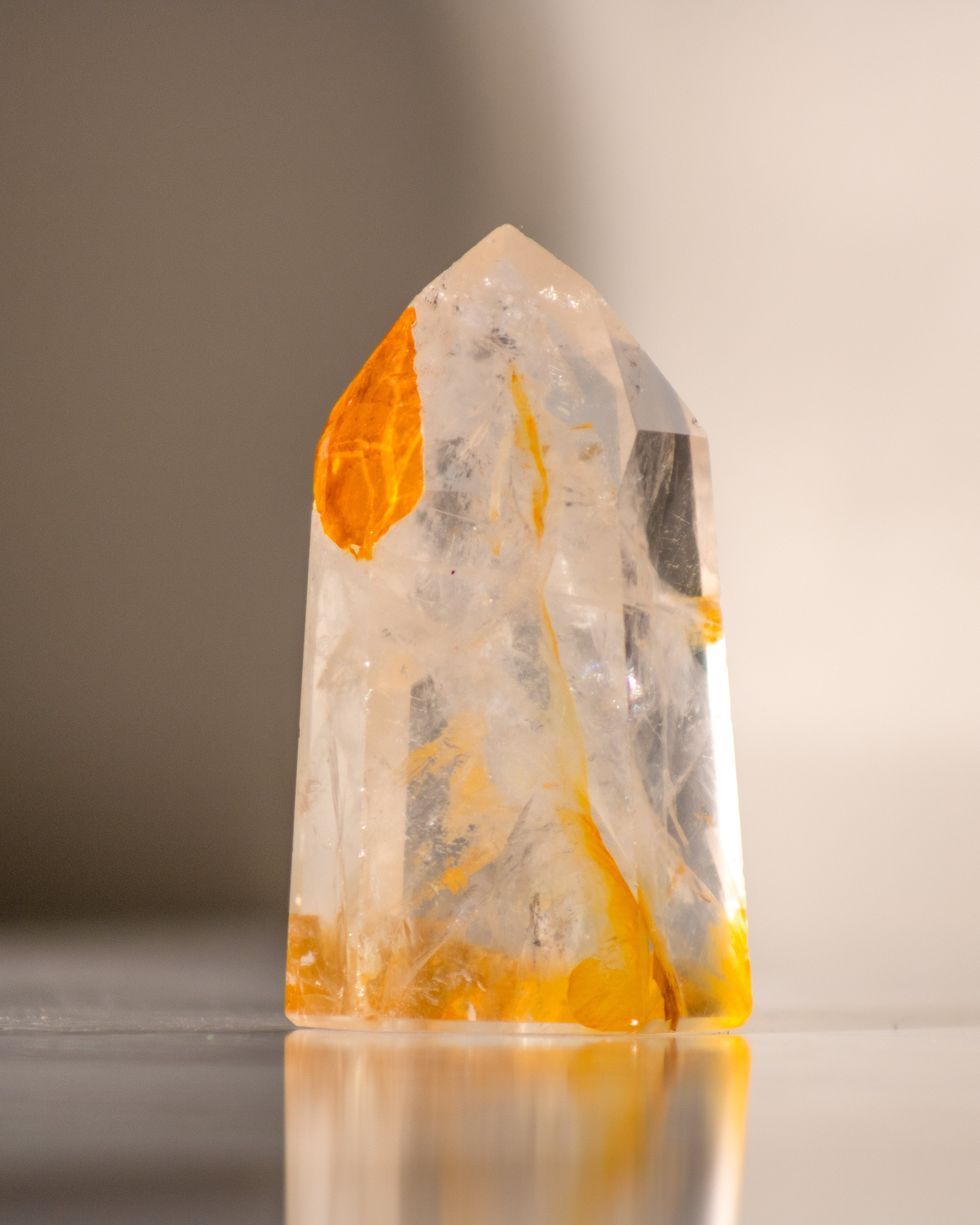 a clear quartz tower with veins of yellow hematite running through it 