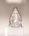 a clear quartz crystal teardrop with brown lines running through it