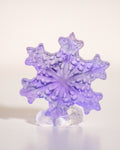a carved purple fluorite crystal in the shape of a snowflake