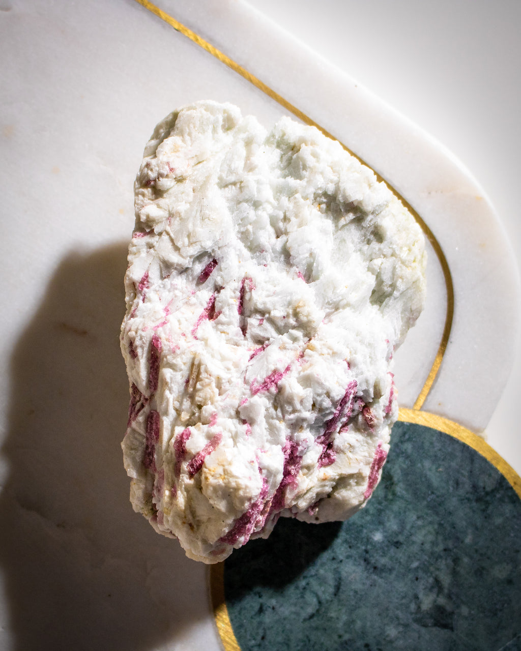 Rock with white and pinkish-red coloration on a textured surface