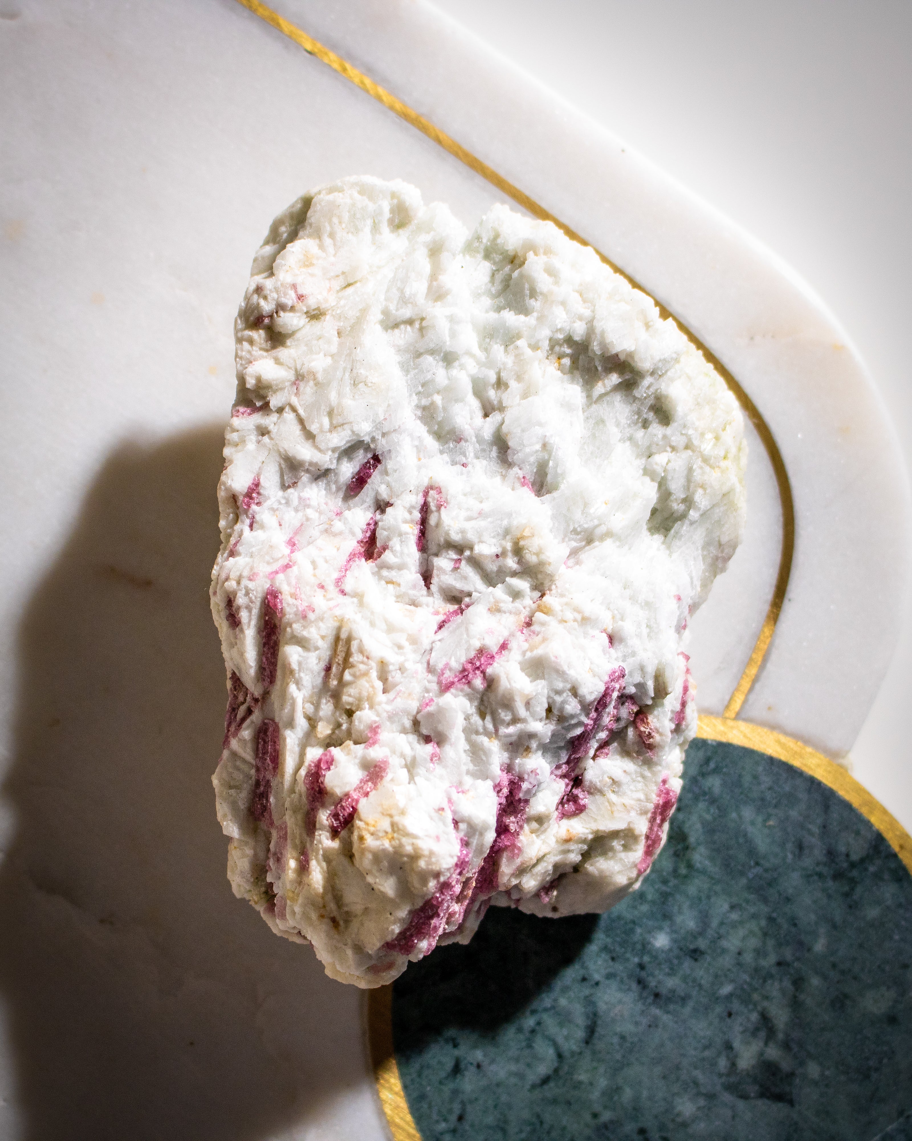 Rock with white and pinkish-red coloration on a textured surface