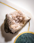 Geode crystal on a marble surface with gold accents