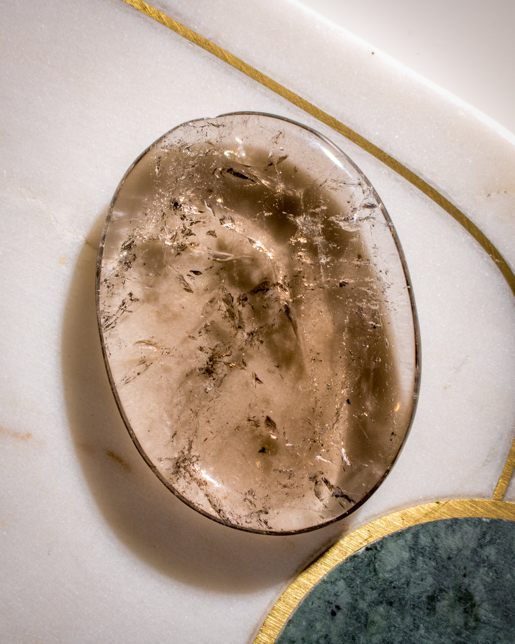 Smoky quartz crystal on a marble surface