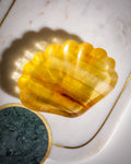 Yellow shell-shaped object on a marble surface