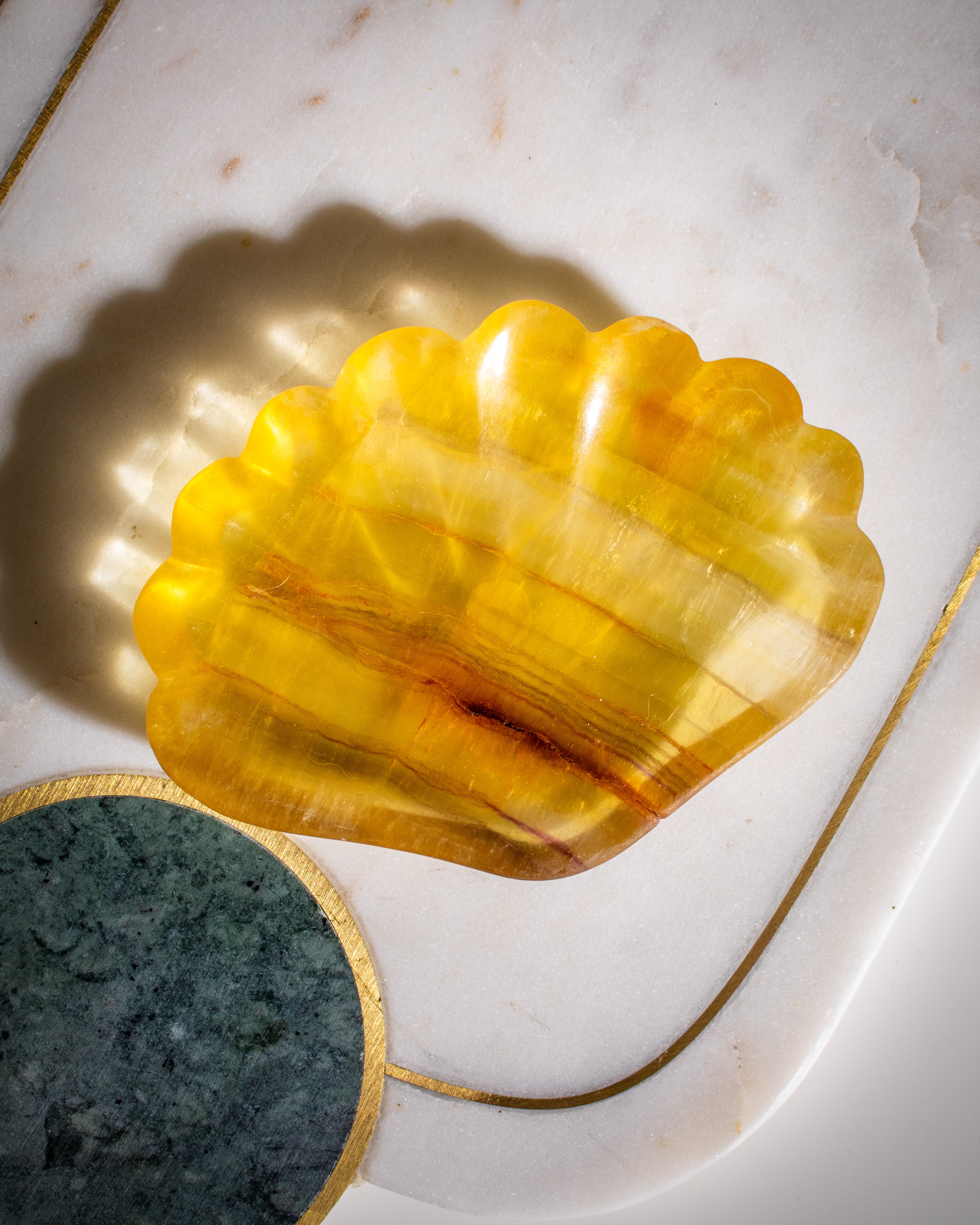 Yellow shell-shaped object on a marble surface