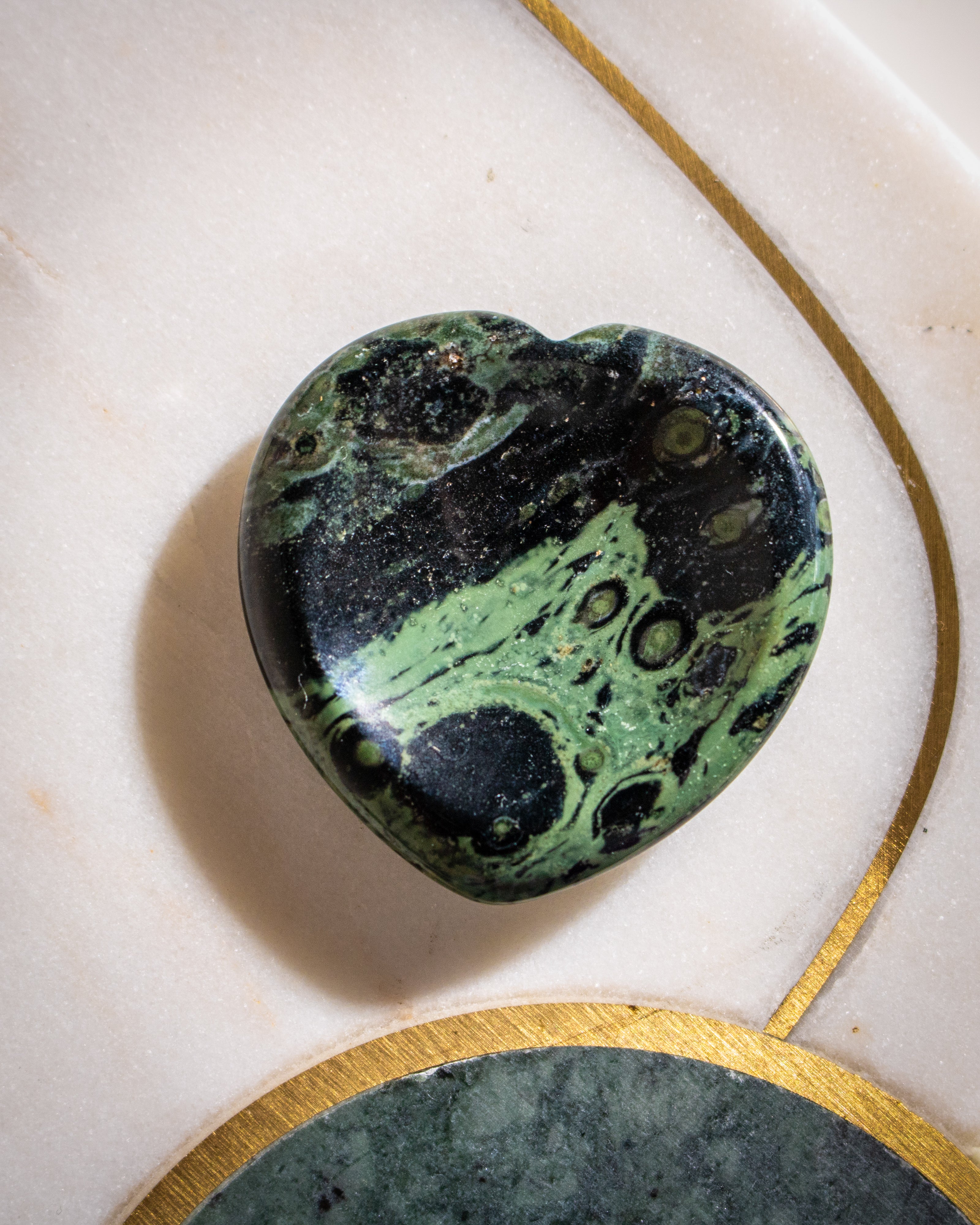 Marbled green and black stone on a light background