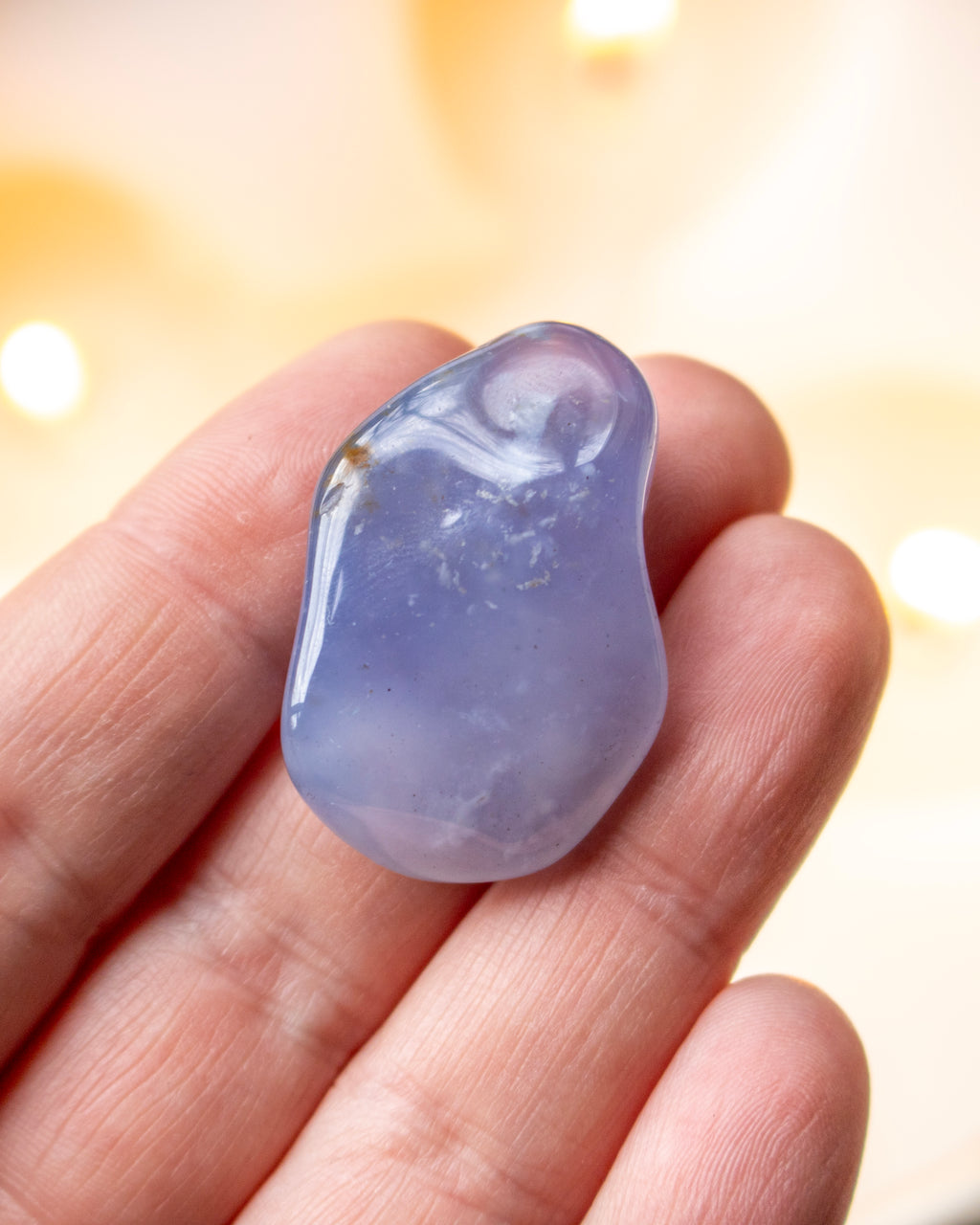 Blue crystal on a hand with a blurred background
