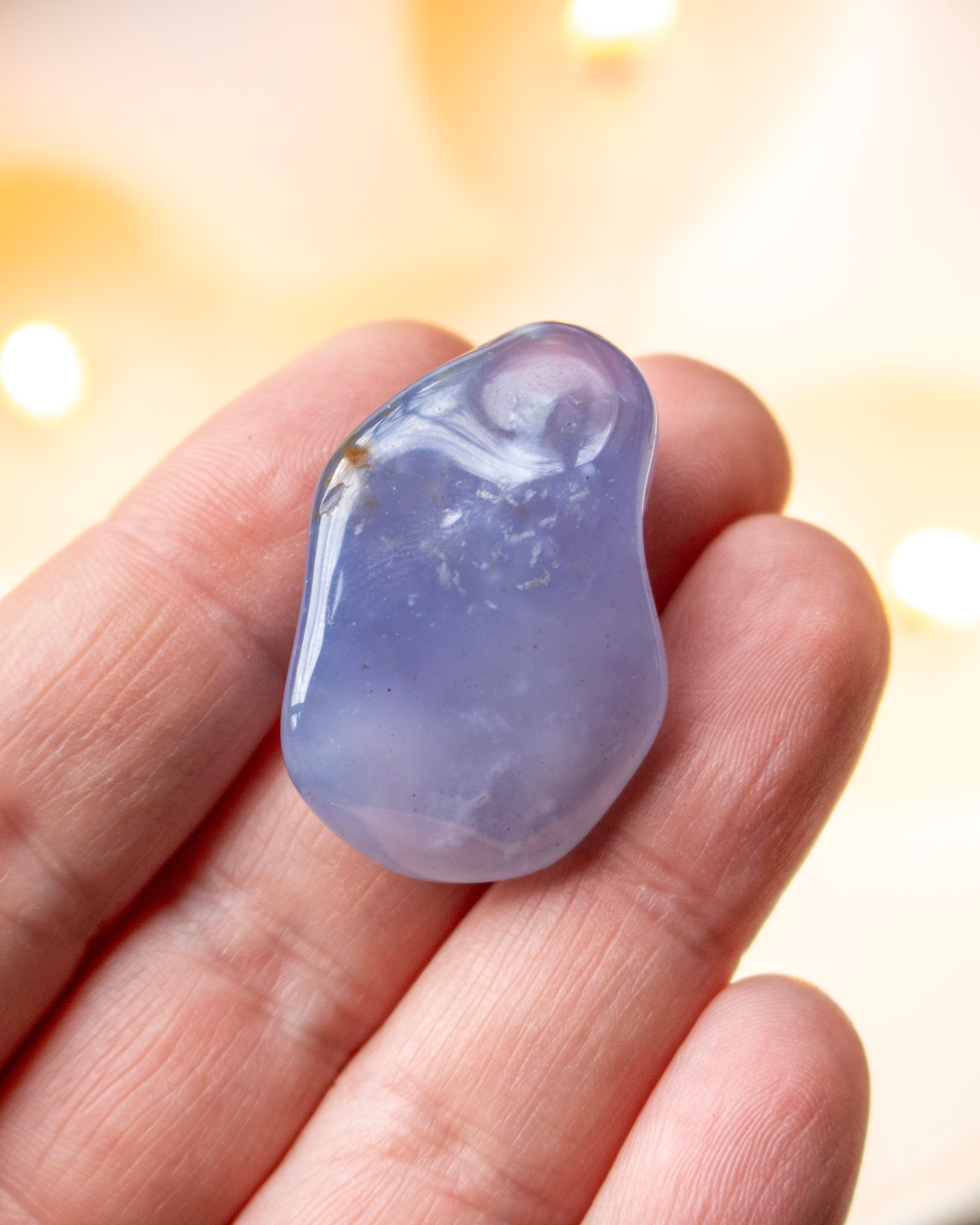 Blue crystal on a hand with a blurred background
