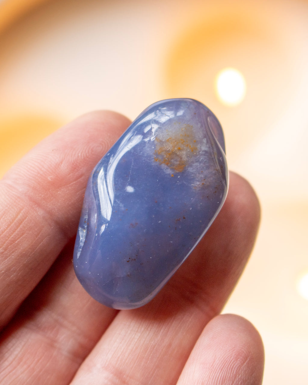 a hand holding a blue stone with a blurred background