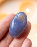 a hand holding a blue stone with a blurred background