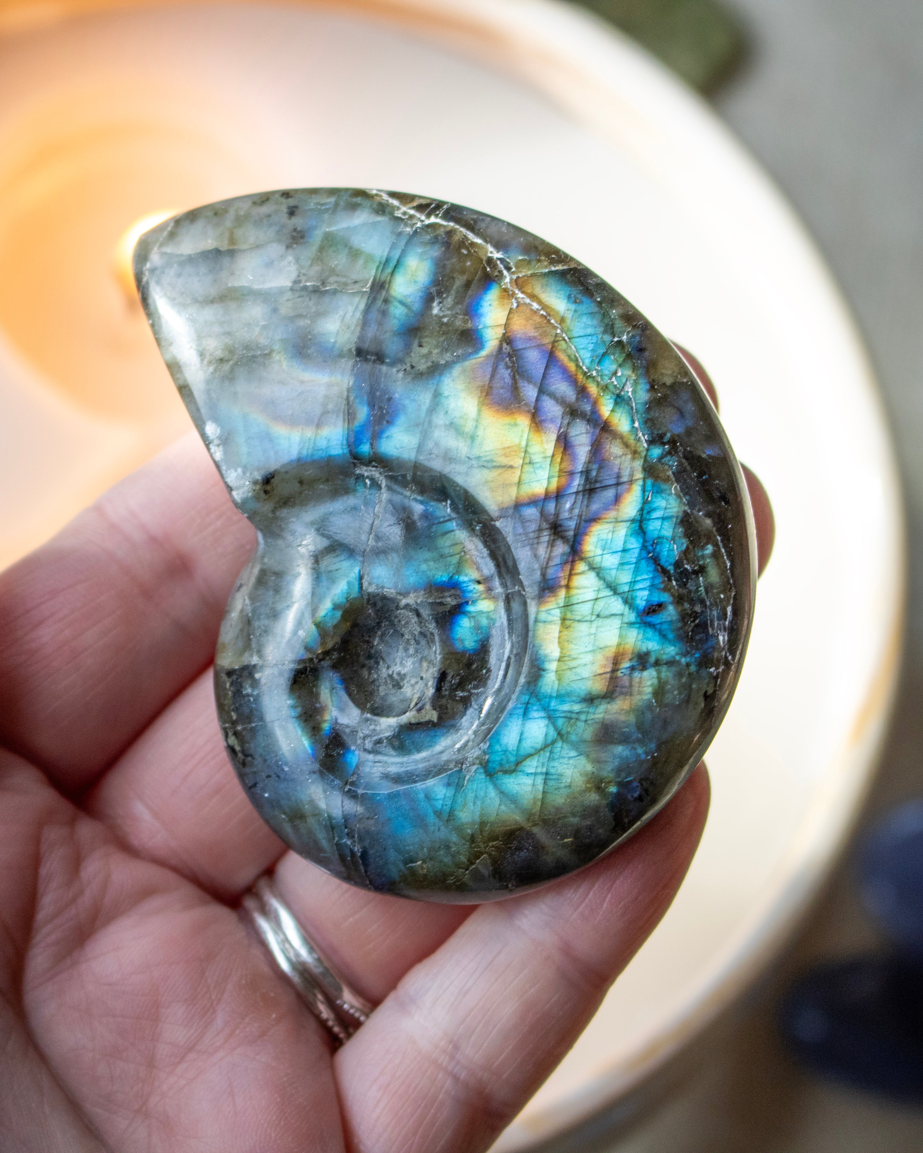 a labradorite stone held in the hand with a spiral shape