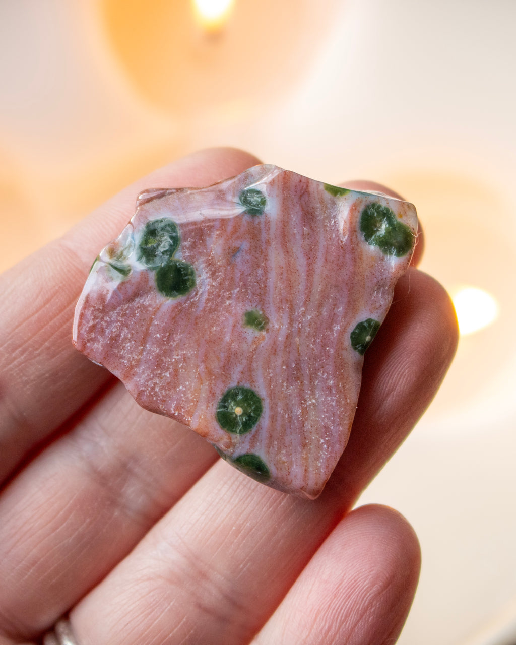 a sea jasper stone in the hand with a blurred background