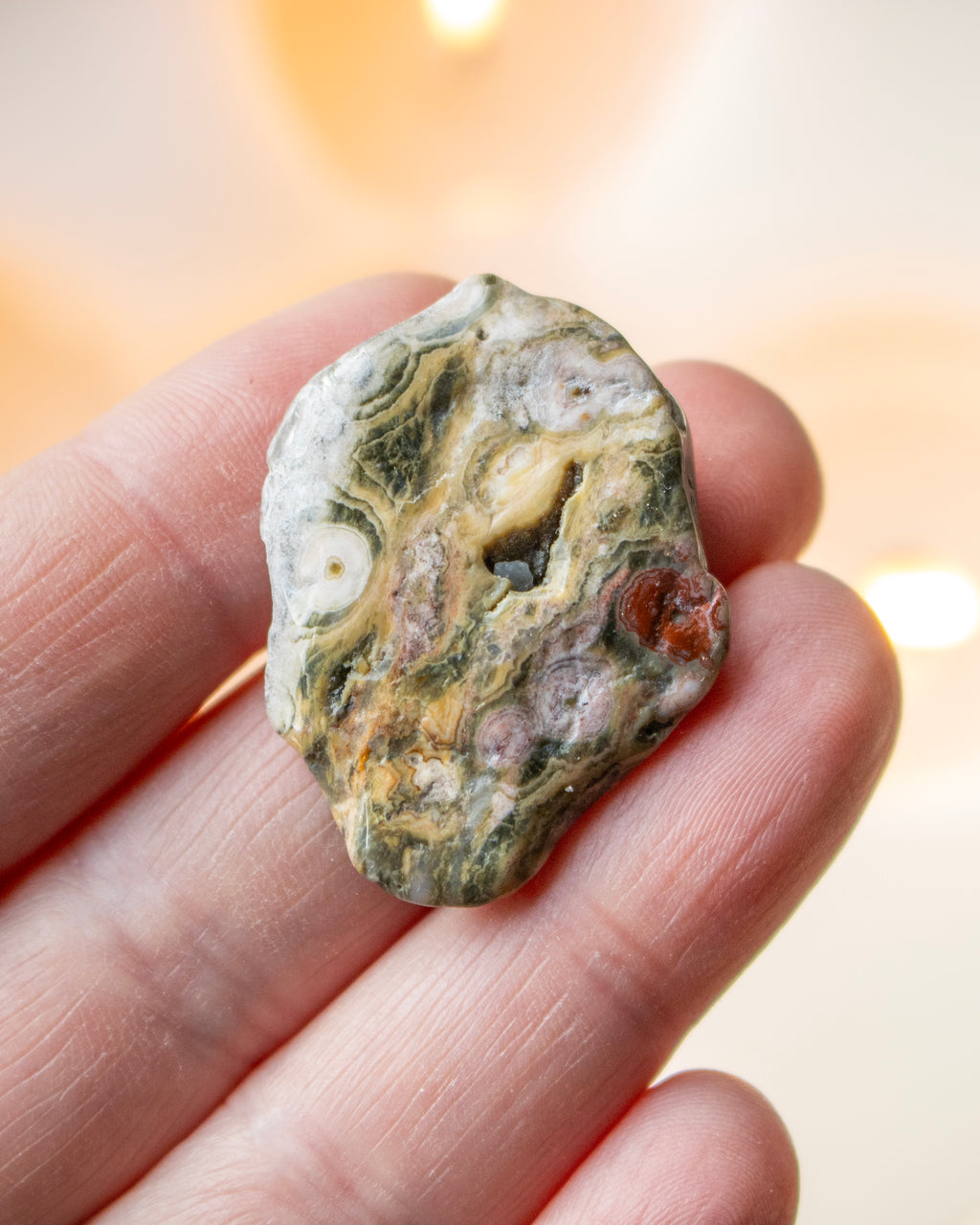 a sea jasper stone in the hand with a blurred background