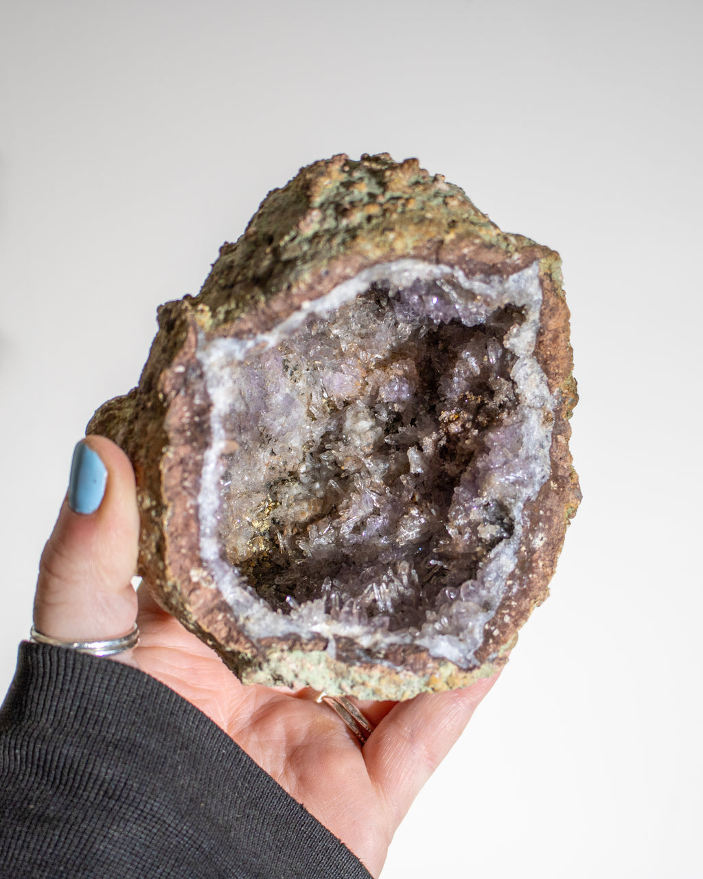 a large geode crystal being held in the hand
