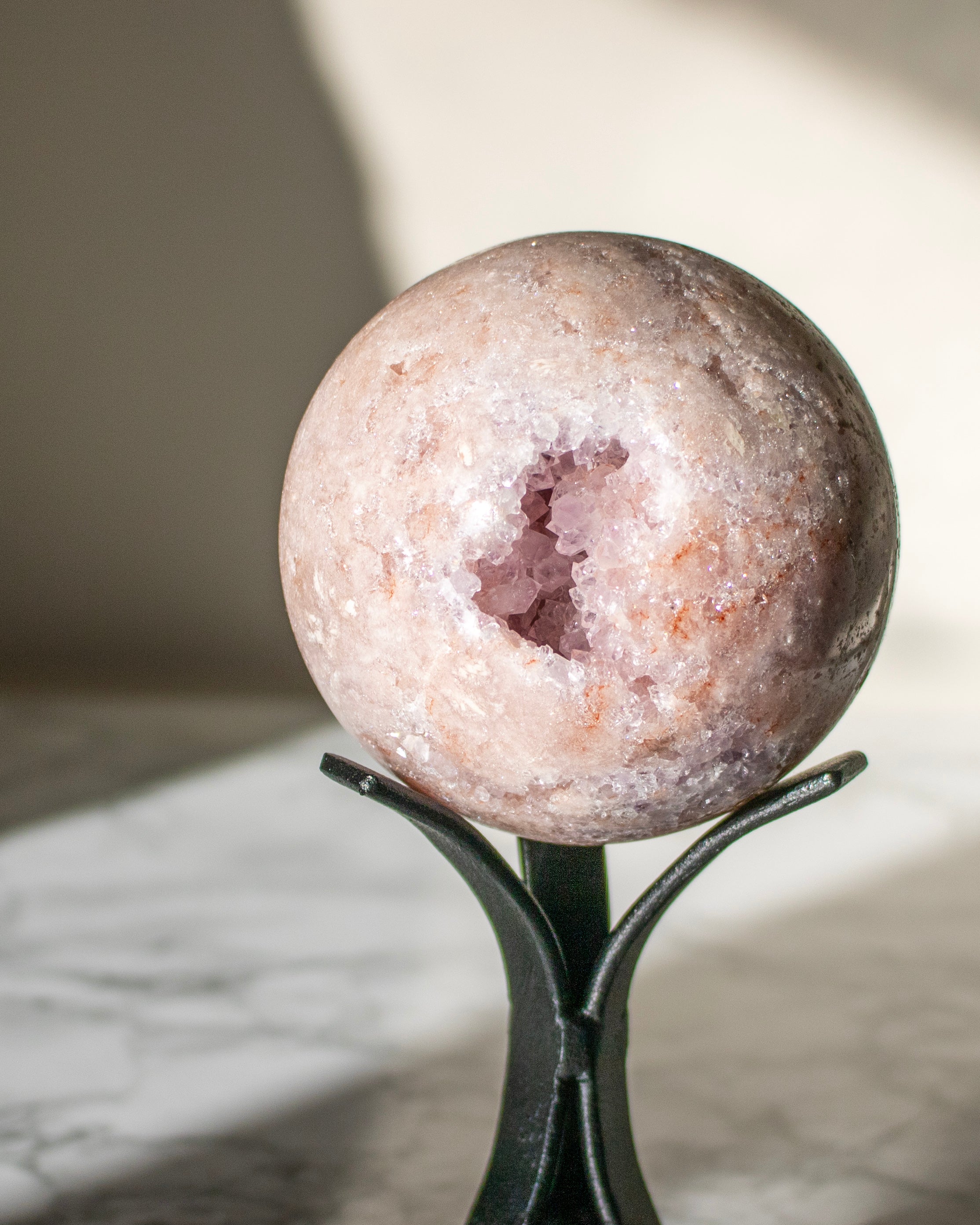 Geode crystal sphere on a stand with a blurred background