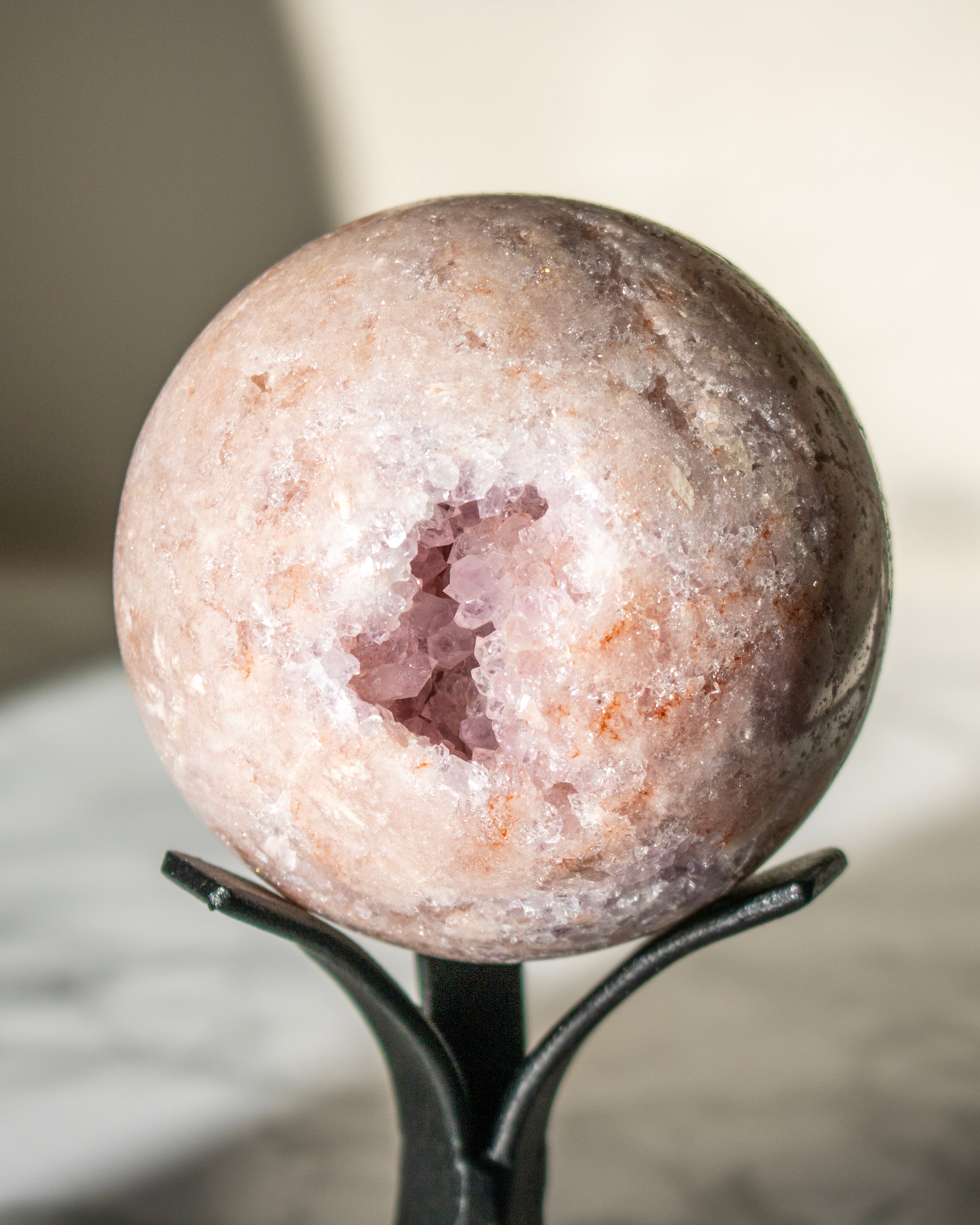 Geode crystal sphere on a stand with a blurred background