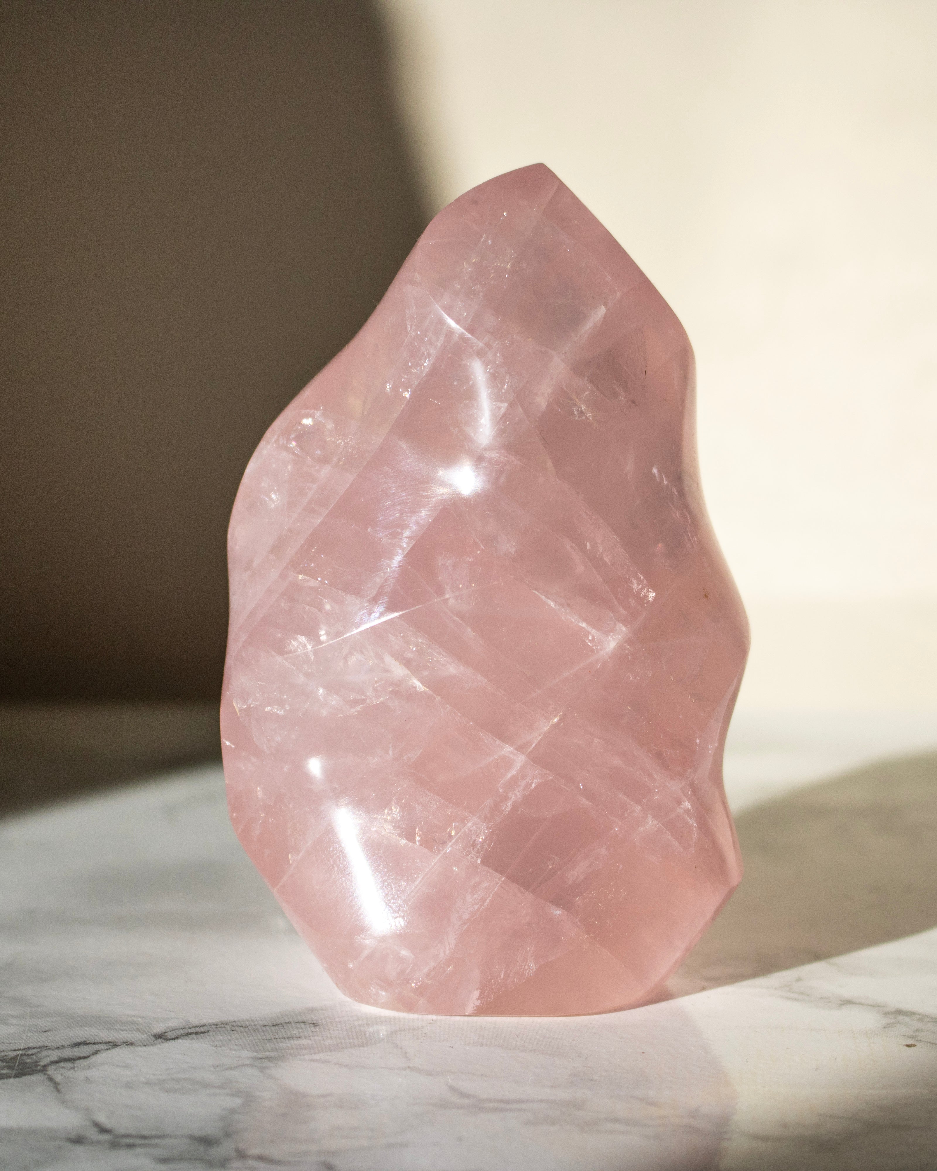 Pink crystal on a marble surface with a soft background