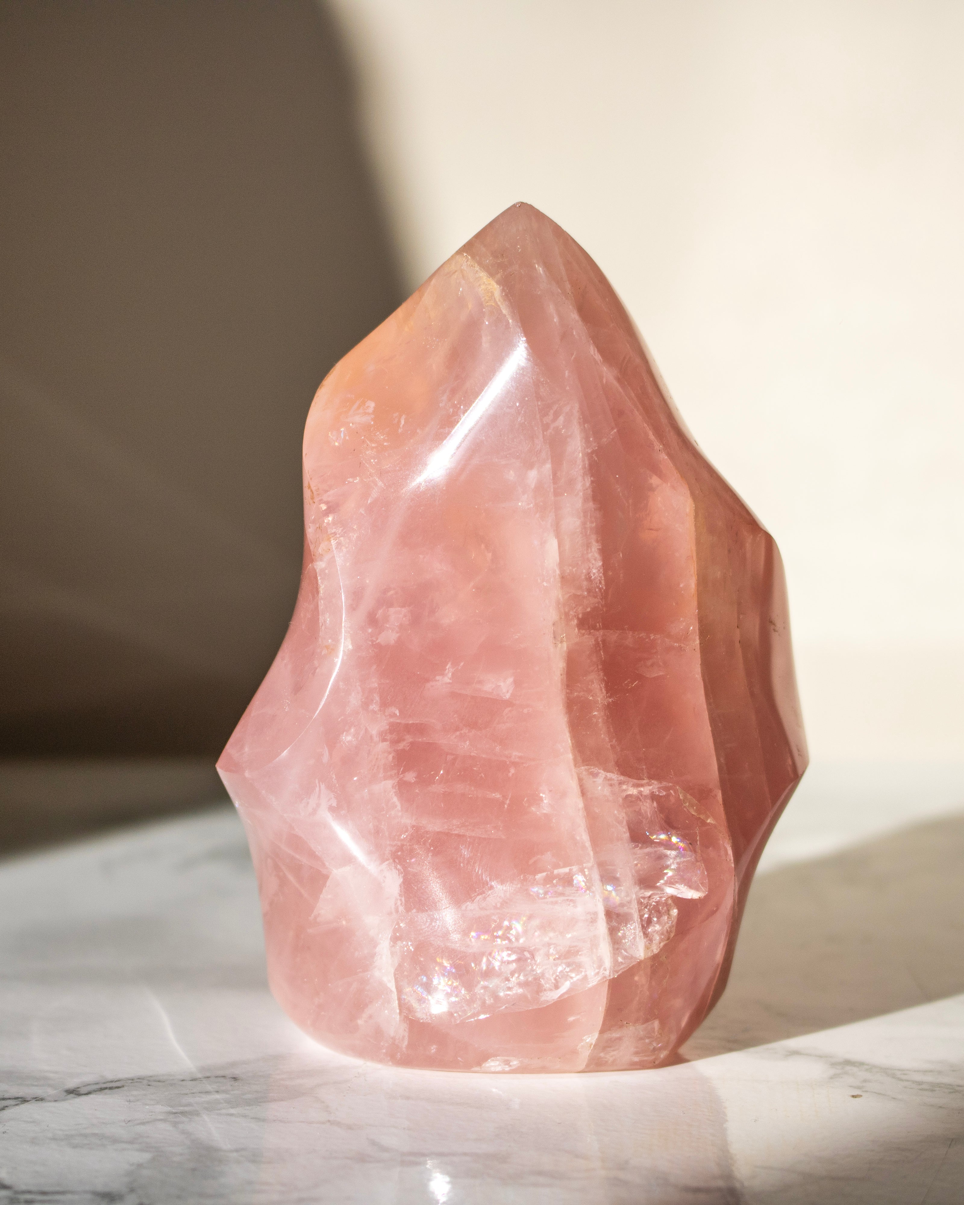 Pink crystal on a marble surface with a neutral background