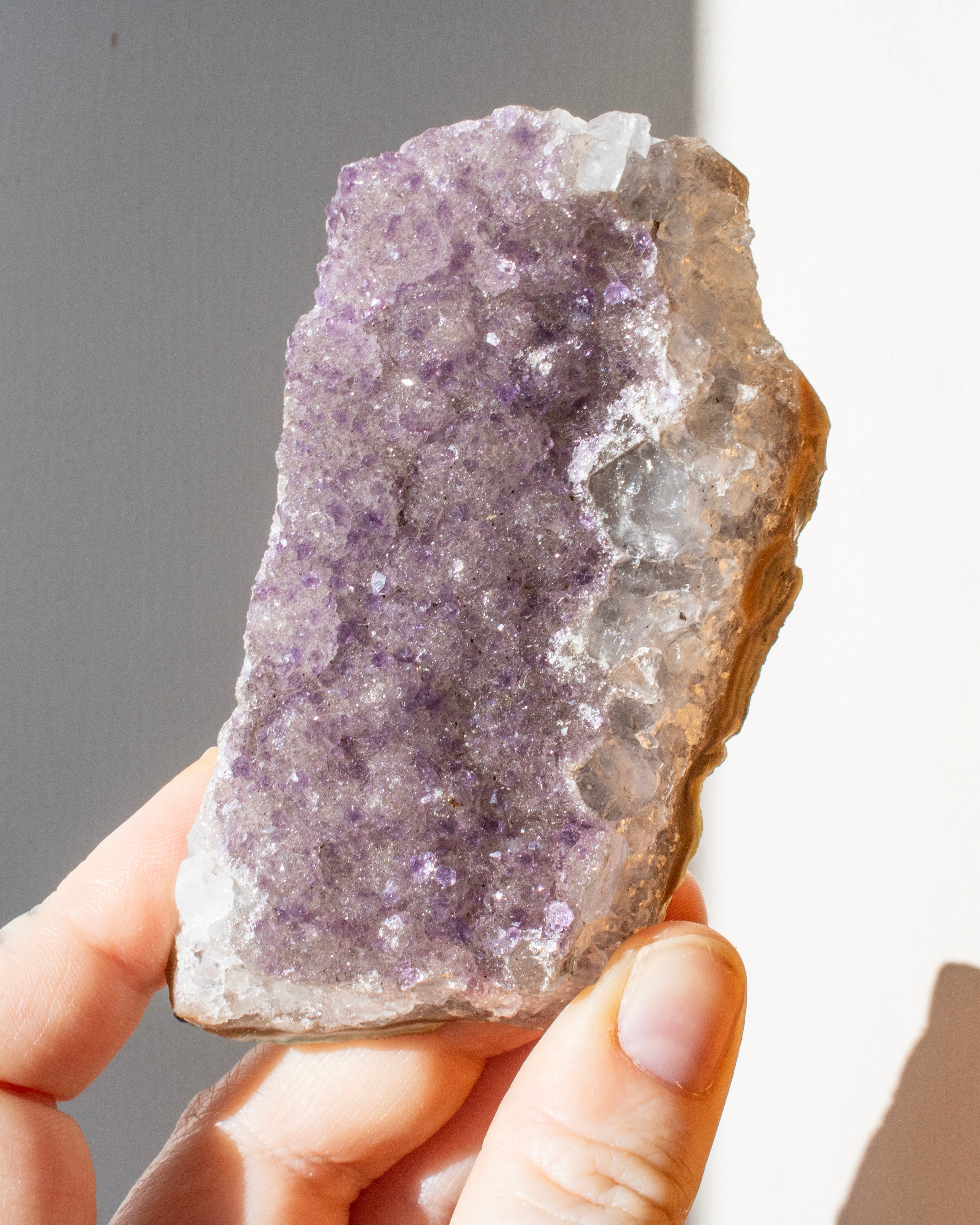 a hand holding an amethyst cluster